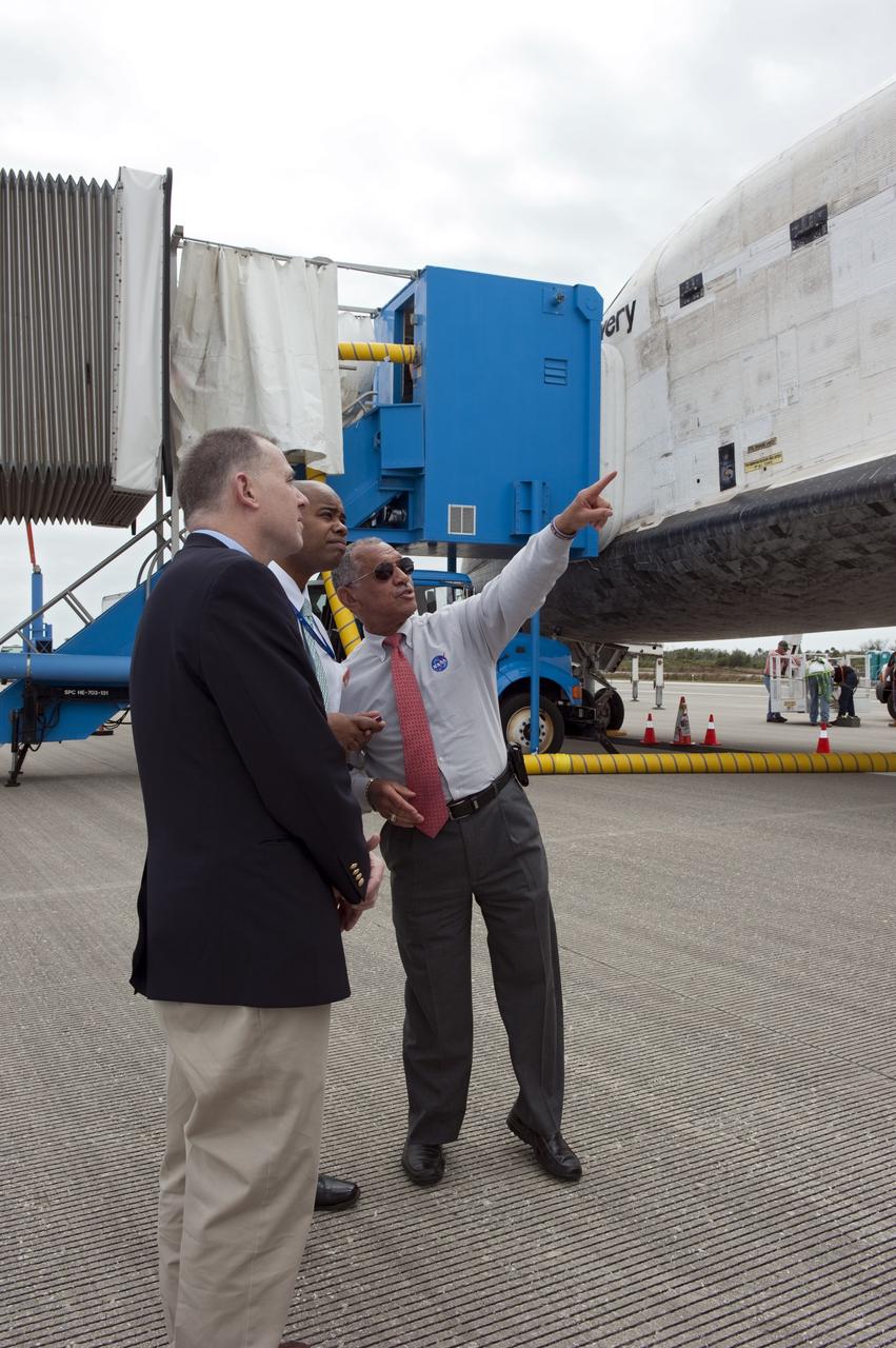 CAPE CANAVERAL, Fla. -- NASA Administrator Charlie Bolden, right, shows off space shuttle Discovery at Kennedy Space Center in Florida, following its final return from space. Touchdown on the Shuttle Landing Facility's Runway 15 was at 11:57 a.m. EST, bringing an end to the 13-day STS-133 mission to the International Space Station.    Discovery and its six-member crew delivered the Permanent Multipurpose Module, packed with supplies and critical spare parts, as well as Robonaut 2, the dexterous humanoid astronaut helper, to the orbiting outpost. STS-133 was Discovery's 39th and final mission. This was the 133rd Space Shuttle Program mission and the 35th shuttle voyage to the space station. Photo credit: NASA/Kim Shiflett
