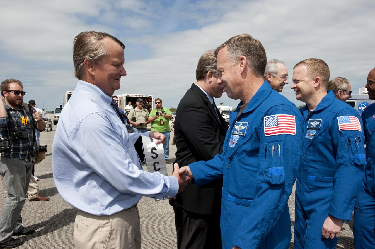 CAPE CANAVERAL, Fla. -- NASA managers welcome space shuttle Discovery's STS-133 crew members home to Kennedy Space Center in Florida. In the foreground, Shuttle Launch Director Mike Leinbach congratulates STS-133 Commander Steve Lindsey on a successful mission. Discovery and its six-member crew landed on the Shuttle Landing Facility's Runway 15 at 11:57 a.m. EST, bringing an end to the 13-day, 5.3-million-mile mission to the International Space Station.    STS-133 delivered the Permanent Multipurpose Module, packed with supplies and critical spare parts, as well as Robonaut 2, the dexterous humanoid astronaut helper, to the orbiting outpost. STS-133 was Discovery's 39th and final mission. This was the 133rd Space Shuttle Program mission and the 35th shuttle voyage to the space station. Photo credit: NASA/Kim Shiflett