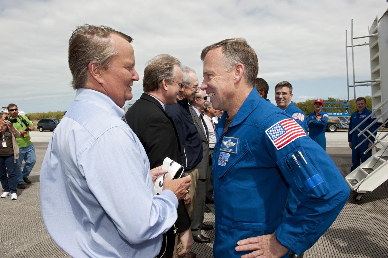 CAPE CANAVERAL, Fla. -- NASA managers welcome space shuttle Discovery's STS-133 crew members home to Kennedy Space Center in Florida. In the foreground, Shuttle Launch Director Mike Leinbach congratulates STS-133 Commander Steve Lindsey on a successful mission. Discovery and its six-member crew landed on the Shuttle Landing Facility's Runway 15 at 11:57 a.m. EST, bringing an end to the 13-day, 5.3-million-mile mission to the International Space Station.    STS-133 delivered the Permanent Multipurpose Module, packed with supplies and critical spare parts, as well as Robonaut 2, the dexterous humanoid astronaut helper, to the orbiting outpost. STS-133 was Discovery's 39th and final mission. This was the 133rd Space Shuttle Program mission and the 35th shuttle voyage to the space station. Photo credit: NASA/Kim Shiflett