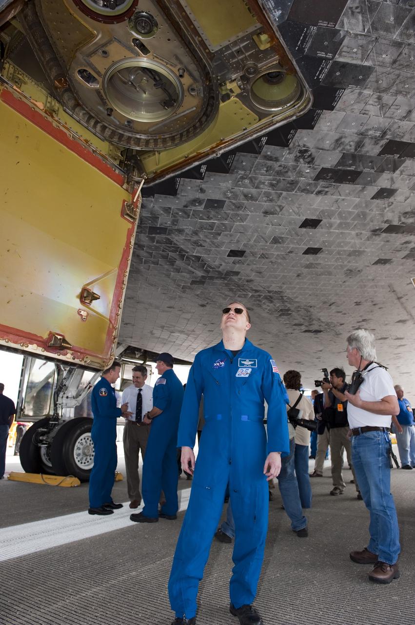 CAPE CANAVERAL, Fla. -- STS-133 Pilot Eric Boe admires space shuttle Discovery on the Shuttle Landing Facility's Runway 15 at NASA's Kennedy Space Center in Florida. Boe and his crewmates returned from a 13-day, 5.3-million-mile mission to the International Space Station at 11:57 a.m. EST.    STS-133 delivered the Permanent Multipurpose Module, packed with supplies and critical spare parts, as well as Robonaut 2, the dexterous humanoid astronaut helper, to the orbiting outpost. STS-133 was Discovery's 39th and final mission. This was the 133rd Space Shuttle Program mission and the 35th shuttle voyage to the space station. Photo credit: NASA/Kim Shiflett