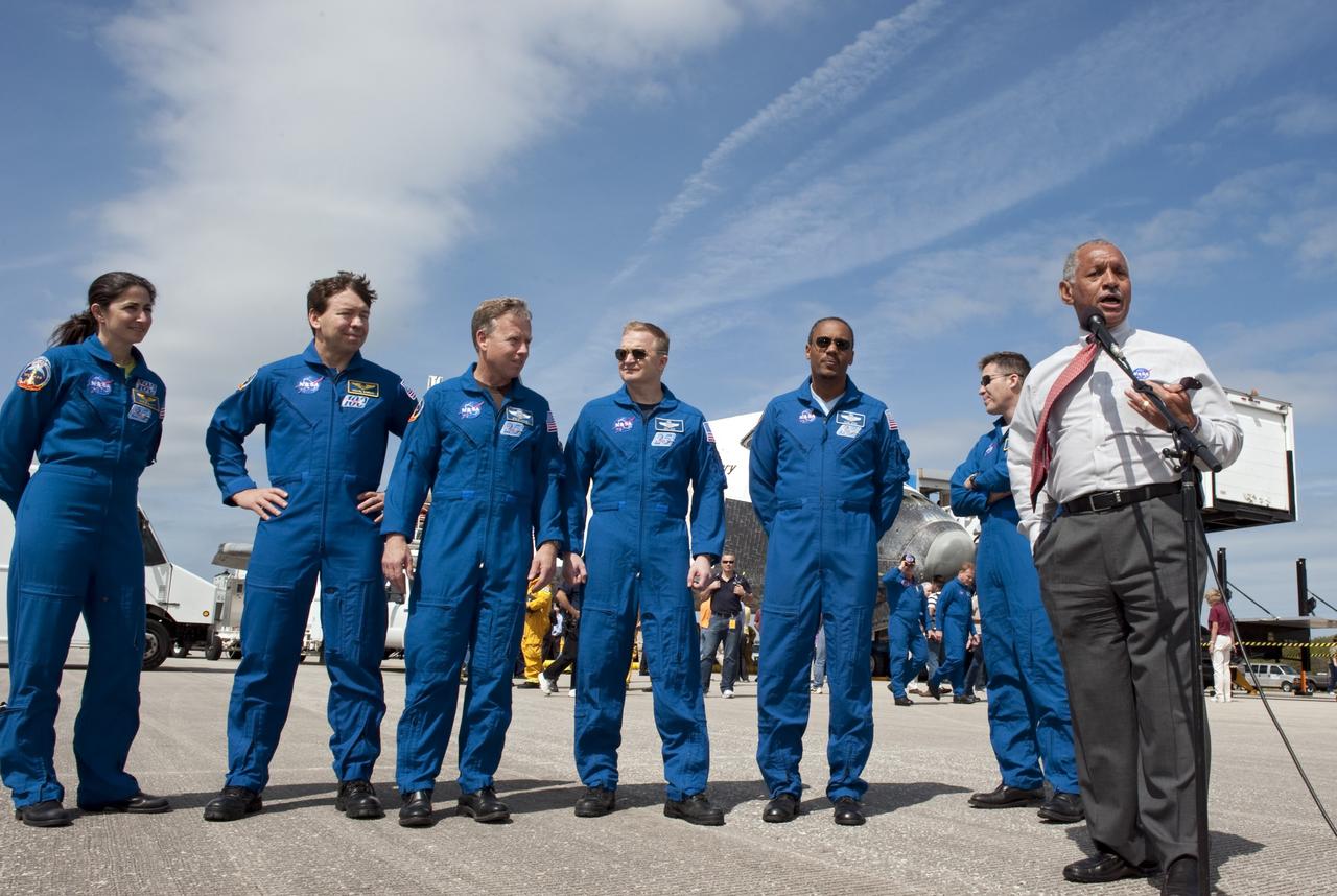 CAPE CANAVERAL, Fla. -- NASA Administrator Charlie Bolden introduces the STS-133 crew to media representatives waiting on the Shuttle Landing Facility at Kennedy Space Center in Florida to hear statements about space shuttle Discovery's final spaceflight mission. Crew members, from left, are Mission Specialists Nicole Stott and Michael Barratt, Commander Steve Lindsey, Pilot Eric Boe and Mission Specialists Alvin Drew and Steve Bowen. The crew returned to Earth at 11:57 a.m. on Runway 15, completing a 13-day, 5.3-million-mile mission to the International Space Station.    STS-133 delivered the Permanent Multipurpose Module, packed with supplies and critical spare parts, as well as Robonaut 2, the dexterous humanoid astronaut helper, to the orbiting outpost. STS-133 was Discovery's 39th and final mission. This was the 133rd Space Shuttle Program mission and the 35th shuttle voyage to the space station. Photo credit: NASA/Kim Shiflett