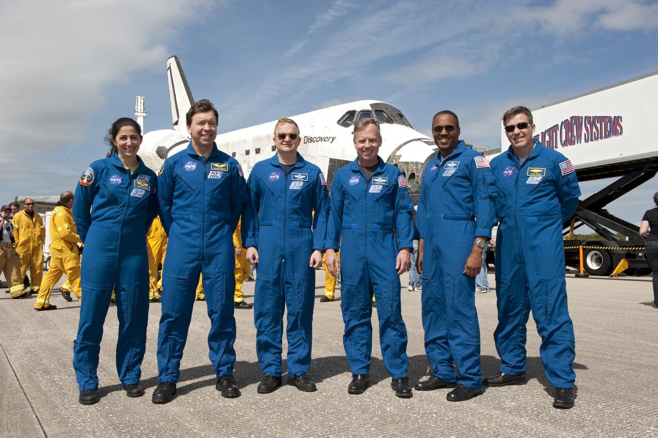 CAPE CANAVERAL, Fla. -- The STS-133 crew poses for a photo in front of space shuttle Discovery on the Shuttle Landing Facility's Runway 15 at NASA's Kennedy Space Center in Florida. From left, are Mission Specialists Nicole Stott and Michael Barratt, Pilot Eric Boe, Commander Steve Lindsey, and Mission Specialists Alvin Drew and Steve Bowen. Discovery and crew returned to Earth at 11:57 a.m., completing a 13-day, 5.3-million-mile mission to the International Space Station.    STS-133 delivered the Permanent Multipurpose Module, packed with supplies and critical spare parts, as well as Robonaut 2, the dexterous humanoid astronaut helper, to the orbiting outpost. STS-133 was Discovery's 39th and final mission. This was the 133rd Space Shuttle Program mission and the 35th shuttle voyage to the space station. Photo credit: NASA/Kim Shiflett
