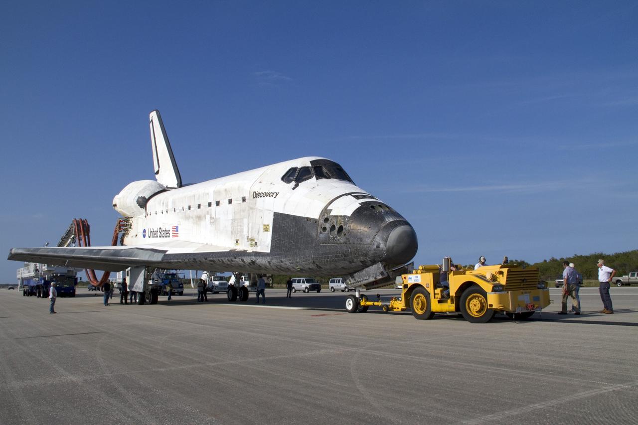 CAPE CANAVERAL, Fla. - Space shuttle Discovery is connected to its "towback" vehicle, which will slowly pull the spacecraft from the Shuttle Landing Facility to Orbiter Processing Facility-2 at NASA's Kennedy Space Center in Florida. A purge unit that pumps conditioned air into a shuttle after landing is connected to Discovery's aft end. Discovery touched down on Runway 15 at 11:57 a.m., bringing an end to its 39th and final spaceflight mission, STS-133. Discovery and its six-member STS-133 crew delivered the Permanent Multipurpose Module, packed with supplies and critical spare parts, as well as Robonaut 2, the dexterous humanoid astronaut helper, to the International Space Station.             Inside the processing facility, Discovery will be prepared for future public display.  Photo credit: NASA/Jack Pfaller