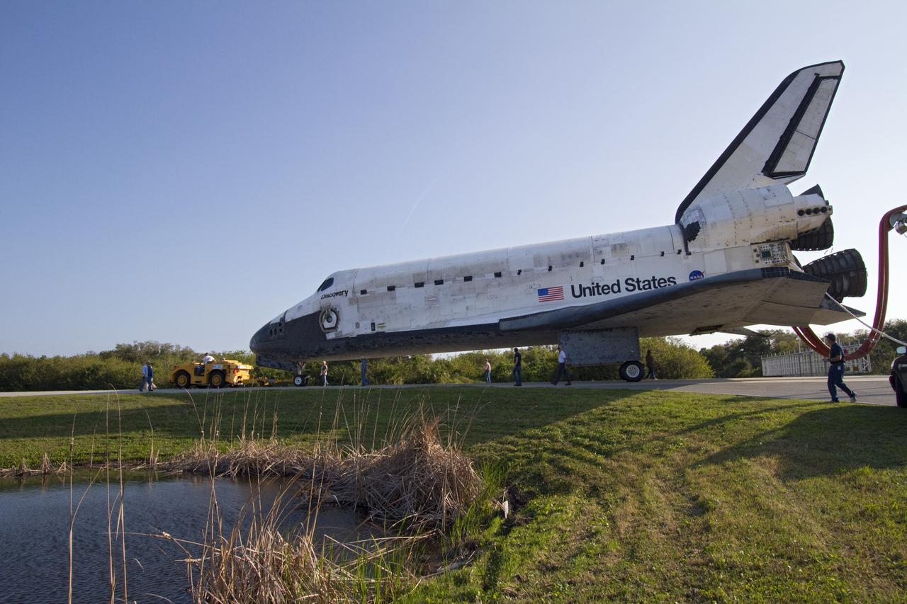 CAPE CANAVERAL, Fla. - Space shuttle Discovery's "towback" vehicle slowly pulls the spacecraft from the Shuttle Landing Facility to Orbiter Processing Facility-2 at NASA's Kennedy Space Center in Florida. A purge unit that pumps conditioned air into a shuttle after landing is connected to Discovery's aft end. Discovery touched down on Runway 15 at 11:57 a.m., bringing an end to its 39th and final spaceflight mission, STS-133. Discovery and its six-member STS-133 crew delivered the Permanent Multipurpose Module, packed with supplies and critical spare parts, as well as Robonaut 2, the dexterous humanoid astronaut helper, to the International Space Station.           Inside the processing facility, Discovery will be prepared for future public display.  Photo credit: NASA/Jack Pfaller