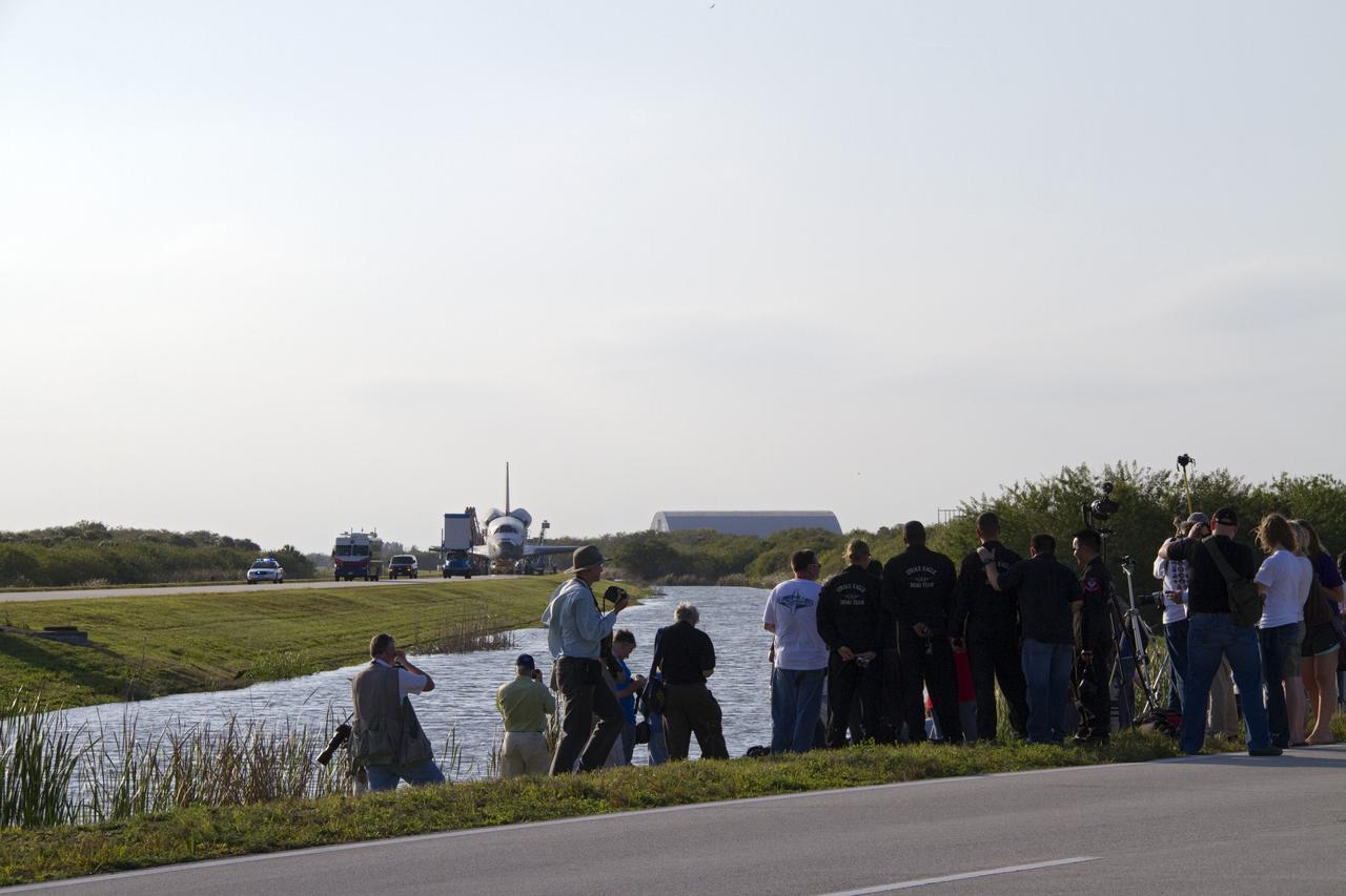 CAPE CANAVERAL, Fla. - Photographers are in position near the towway to capture space shuttle Discovery as it is towed from the Shuttle Landing Facility to Orbiter Processing Facility-2 at NASA's Kennedy Space Center in Florida. Discovery touched down on Runway 15 at 11:57 a.m., bringing an end to its 39th and final spaceflight mission, STS-133. Discovery and its six-member STS-133 crew delivered the Permanent Multipurpose Module, packed with supplies and critical spare parts, as well as Robonaut 2, the dexterous humanoid astronaut helper, to the International Space Station.    Inside the processing facility, Discovery will be prepared for future public display.  Photo credit: NASA/Jack Pfaller