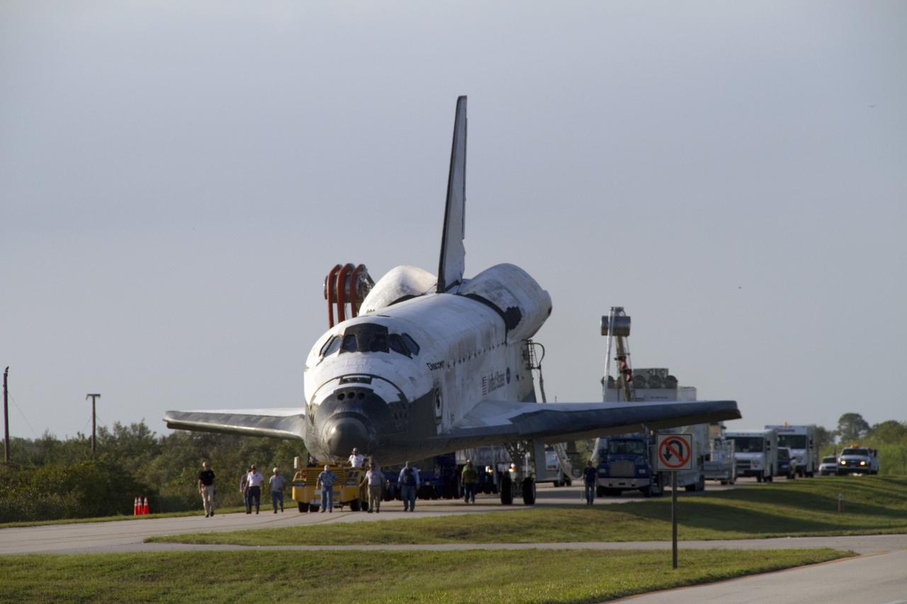CAPE CANAVERAL, Fla. - Space shuttle Discovery's "towback" vehicle slowly pulls the spacecraft from the Shuttle Landing Facility to Orbiter Processing Facility-2 at NASA's Kennedy Space Center in Florida. A purge unit that pumps conditioned air into a shuttle after landing is connected to Discovery's aft end and additional landing convoy vehicles follow closely behind. Discovery touched down on Runway 15 at 11:57 a.m., bringing an end to its 39th and final spaceflight mission, STS-133. Discovery and its six-member STS-133 crew delivered the Permanent Multipurpose Module, packed with supplies and critical spare parts, as well as Robonaut 2, the dexterous humanoid astronaut helper, to the International Space Station.             Inside the processing facility, Discovery will be prepared for future public display.  Photo credit: NASA/Jack Pfaller
