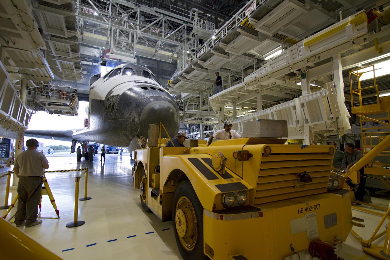 CAPE CANAVERAL, Fla. - A "towback" vehicle slowly pulls space shuttle Discovery through the open door of Orbiter Processing Facility-2 at NASA's Kennedy Space Center in Florida. Discovery touched down on the Shuttle Landing Facility's Runway 15 at 11:57 a.m., bringing an end to its 39th and final spaceflight mission, STS-133. Discovery and its six-member STS-133 crew delivered the Permanent Multipurpose Module, packed with supplies and critical spare parts, as well as Robonaut 2, the dexterous humanoid astronaut helper, to the International Space Station.     Inside the processing facility, Discovery will be prepared for future public display.  Photo credit: NASA/Jack Pfaller