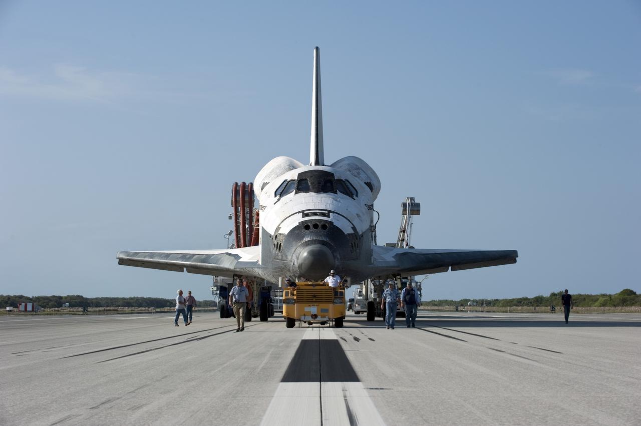 CAPE CANAVERAL, Fla. - Employees accompany space shuttle Discovery as it is pulled by a "towback" vehicle from the Shuttle Landing Facility to Orbiter Processing Facility-2 at NASA's Kennedy Space Center in Florida. Discovery touched down on Runway 15 at 11:57 a.m., bringing an end to its 39th and final spaceflight mission, STS-133. Discovery and its six-member STS-133 crew delivered the Permanent Multipurpose Module, packed with supplies and critical spare parts, as well as Robonaut 2, the dexterous humanoid astronaut helper, to the International Space Station.    Inside the processing facility, Discovery will be prepared for future public display.  Photo credit: NASA/Kim Shiflett