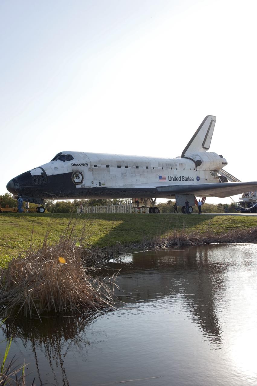 CAPE CANAVERAL, Fla. - Space shuttle Discovery casts a shadow in the water beside the towway on its slow trip from the Shuttle Landing Facility to Orbiter Processing Facility-2 at NASA's Kennedy Space Center in Florida. Discovery touched down on Runway 15 at 11:57 a.m., bringing an end to its 39th and final spaceflight mission, STS-133. Discovery and its six-member STS-133 crew delivered the Permanent Multipurpose Module, packed with supplies and critical spare parts, as well as Robonaut 2, the dexterous humanoid astronaut helper, to the International Space Station.    Inside the processing facility, Discovery will be prepared for future public display.  Photo credit: NASA/Kim Shiflett