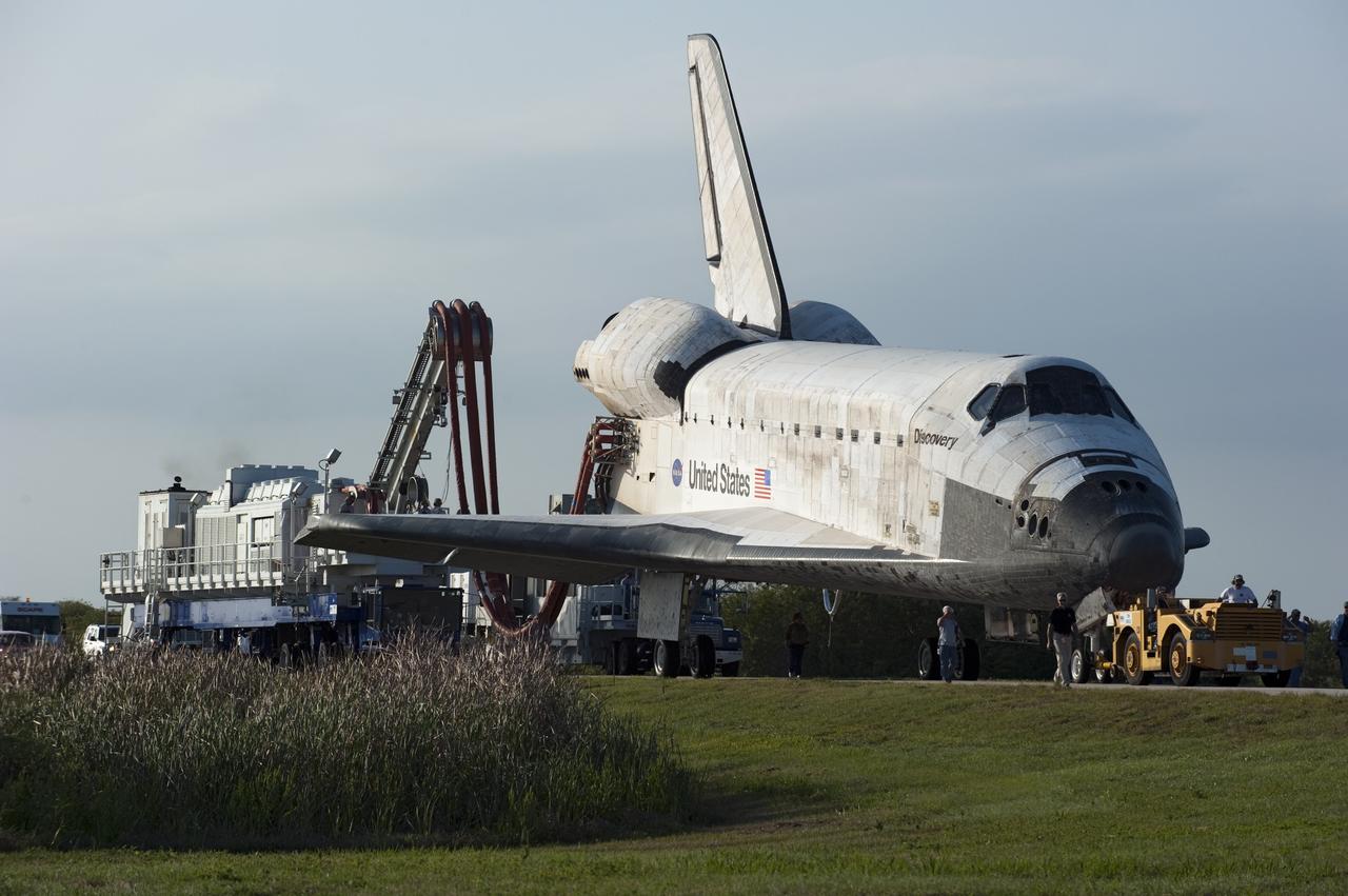 CAPE CANAVERAL, Fla. - Space shuttle Discovery's "towback" vehicle slowly pulls the spacecraft from the Shuttle Landing Facility to Orbiter Processing Facility-2 at NASA's Kennedy Space Center in Florida. A purge unit that pumps conditioned air into a shuttle after landing is connected to Discovery's aft end. Discovery touched down on Runway 15 at 11:57 a.m., bringing an end to its 39th and final spaceflight mission, STS-133. Discovery and its six-member STS-133 crew delivered the Permanent Multipurpose Module, packed with supplies and critical spare parts, as well as Robonaut 2, the dexterous humanoid astronaut helper, to the International Space Station.    Inside the processing facility, Discovery will be prepared for future public display.  Photo credit: NASA/Kim Shiflett