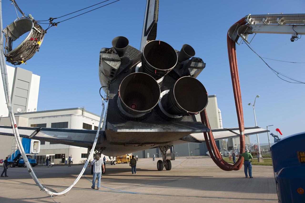 CAPE CANAVERAL, Fla. - The nozzles of two orbital maneuvering system pods and three space shuttle main engines protrude from the aft end of space shuttle Discovery as it is pulled by a "towback" vehicle toward Orbiter Processing Facility-2 at NASA's Kennedy Space Center in Florida. Discovery touched down on the Shuttle Landing Facility's Runway 15 at 11:57 a.m., bringing an end to its 39th and final spaceflight mission, STS-133. Discovery and its six-member STS-133 crew delivered the Permanent Multipurpose Module, packed with supplies and critical spare parts, as well as Robonaut 2, the dexterous humanoid astronaut helper, to the International Space Station.    Inside the processing facility, Discovery will be prepared for future public display.  Photo credit: NASA/Kim Shiflett