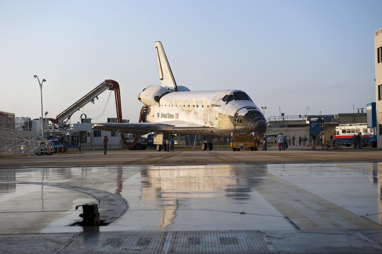CAPE CANAVERAL, Fla. - Space shuttle Discovery, attached to a purge unit that pumps conditioned air into the shuttle while it is towed, is reflected in the entranceway to Orbiter Processing Facility-2 at NASA's Kennedy Space Center in Florida. Discovery touched down on the Shuttle Landing Facility's Runway 15 at 11:57 a.m., bringing an end to its 39th and final spaceflight mission, STS-133. Discovery and its six-member STS-133 crew delivered the Permanent Multipurpose Module, packed with supplies and critical spare parts, as well as Robonaut 2, the dexterous humanoid astronaut helper, to the International Space Station. Inside the processing facility, Discovery will be prepared for future public display. Photo credit: NASA/Kim Shiflett