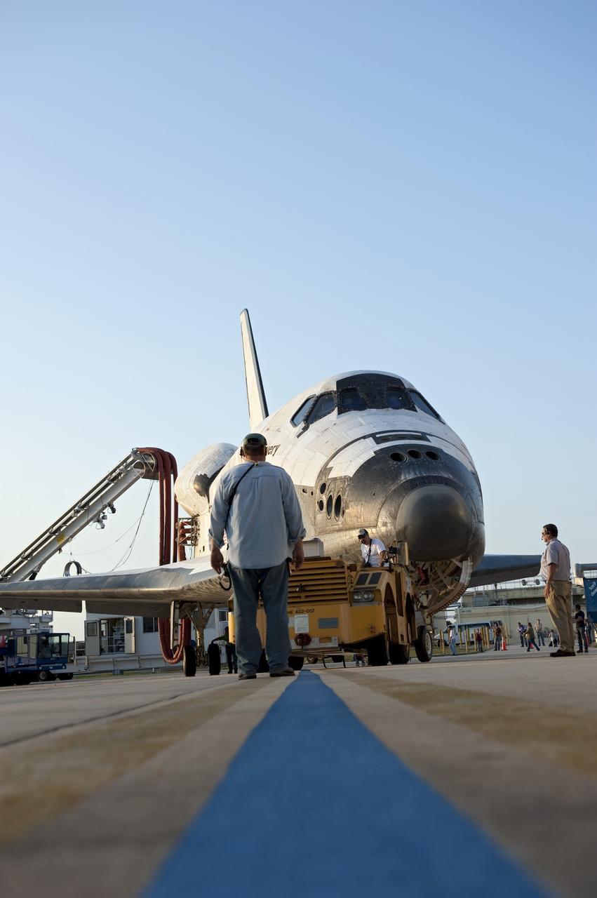 CAPE CANAVERAL, Fla. - The "towback" vehicle lines up space shuttle Discovery for entry into Orbiter Processing Facility-2 at NASA's Kennedy Space Center in Florida. Discovery touched down on the Shuttle Landing Facility's Runway 15 at 11:57 a.m., bringing an end to its 39th and final spaceflight mission, STS-133. Discovery and its six-member STS-133 crew delivered the Permanent Multipurpose Module, packed with supplies and critical spare parts, as well as Robonaut 2, the dexterous humanoid astronaut helper, to the International Space Station.    Inside the processing facility, Discovery will be prepared for future public display.  Photo credit: NASA/Kim Shiflett