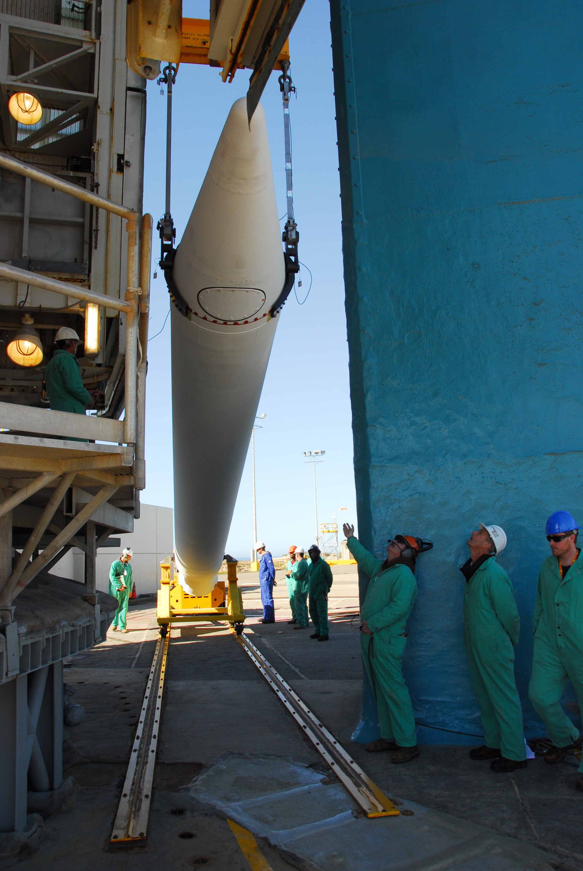 VANDENBERG AIR FORCE BASE, Calif. --At Vandenberg Air Force Base in California, a crane raises one of three United Launch Alliance Delta II solid rocket motors on the pad at Space Launch Complex-2 West (SLC-2W). Scheduled to launch in June, the Delta II rocket will carry NASA's Aquarius satellite into low Earth orbit.    Aquarius' mission will be to provide monthly maps of global changes in sea surface salinity. By measuring ocean salinity from space, Aquarius will provide new insights into how the massive natural exchange of freshwater between the ocean, atmosphere and sea ice influences ocean circulation, weather and climate. Also going up with the satellite are optical and thermal cameras, a microwave radiometer and the SAC-D spacecraft, which were developed with the help of institutions in Italy, France, Canada and Argentina. Photo credit: VAFB/30th Space Wing