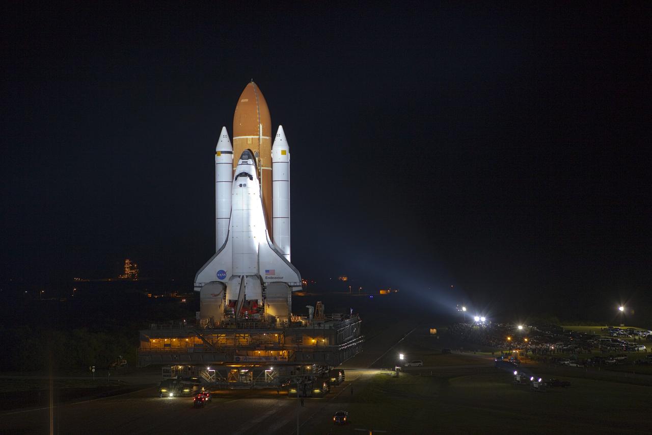 CAPE CANAVERAL, Fla. -- Bathed in xenon lights, space shuttle Endeavour moves along the crawlerway from the Vehicle Assembly Building to Launch Pad 39A, illuminated in the background, at NASA's Kennedy Space Center in Florida.    Riding atop a crawler-transporter attached to its external fuel tank and solid rocket boosters, Endeavour's 3.4-mile trek, known as "rollout," began at 7:56 p.m. EST and will take about seven hours to complete. This is the final scheduled rollout for Endeavour.  Endeavour and its six-member crew will deliver the Express Logistics Carrier-3, Alpha Magnetic Spectrometer-2 (AMS), a high-pressure gas tank, additional spare parts for the Dextre robotic helper and micrometeoroid debris shields to the International Space Station on the shuttle's final spaceflight, STS-134. Launch is targeted for 7:48 p.m. EDT April 19. For more information, visit www.nasa.gov/mission_pages/shuttle/shuttlemissions/sts134/index.html. Photo credit: NASA/Terry Zaperach