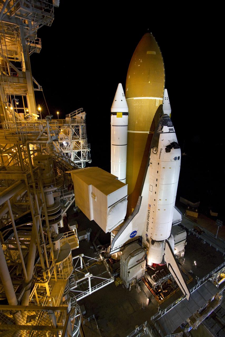 CAPE CANAVERAL, Fla. -- The orbiter access arm swings into position toward space shuttle Endeavour at Launch Pad 39A at NASA's Kennedy Space Center in Florida.    Riding atop a crawler-transporter attached to its external fuel tank and solid rocket boosters, Endeavour's 3.4-mile trek, known as "rollout," began at the Vehicle Assembly Building at 7:56 p.m. EST March 10 and ended at 3:49 a.m. EST, nearly eight hours later. This is Endeavour's final scheduled rollout.  Endeavour and its six-member crew will deliver the Express Logistics Carrier-3, Alpha Magnetic Spectrometer-2 (AMS), a high-pressure gas tank, additional spare parts for the Dextre robotic helper and micrometeoroid debris shields to the International Space Station on the shuttle's final spaceflight, STS-134. Launch is targeted for 7:48 p.m. EDT April 19. For more information, visit www.nasa.gov/mission_pages/shuttle/shuttlemissions/sts134/index.html. Photo credit: NASA/Jack Pfaller