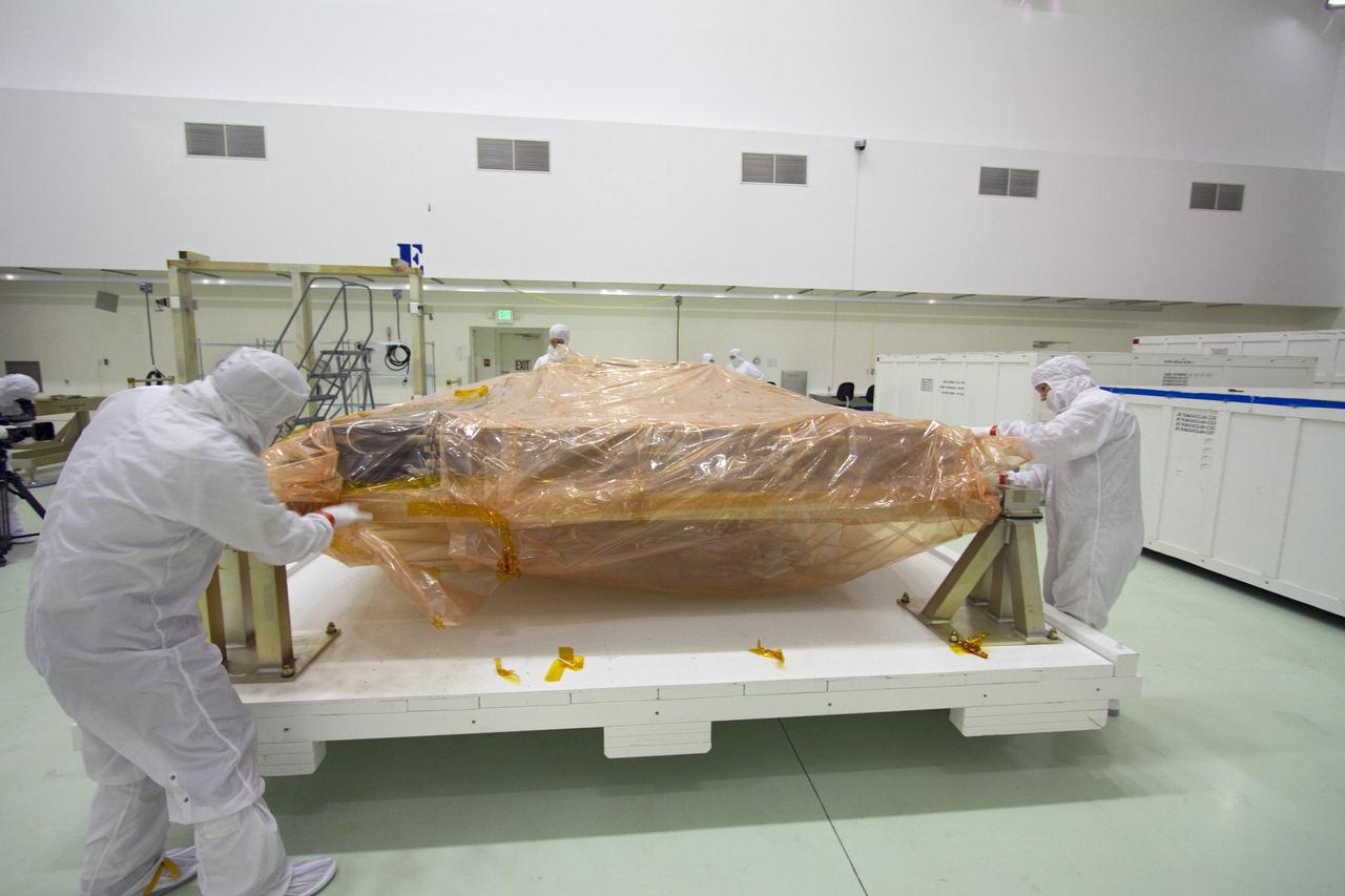 TITUSVILLE, Fla. -- Technicians in the Astrotech payload processing facility in Titusville, Fla., unpack a solar panel that will help power NASA's Juno spacecraft on a mission to Jupiter. Power-generating panels on three sets of solar arrays will extend outward from Juno’s hexagonal body, giving the overall spacecraft a span of more than 66 feet in order to operate at such a great distance from the sun. Juno is scheduled to launch aboard an Atlas V rocket from Cape Canaveral, Fla., on Aug. 5, 2011, reaching Jupiter in July 2016. The spacecraft will orbit the giant planet more than 30 times, skimming to within 3,000 miles above its cloud tops, for about one year. With its suite of science instruments, the spacecraft will investigate the existence of a solid planetary core, map Jupiter's intense magnetic field, measure the amount of water and ammonia in the deep atmosphere, and observe the planet's auroras. For more information visit, www.nasa.gov/juno. Photo credit: NASA/Jack Pfaller