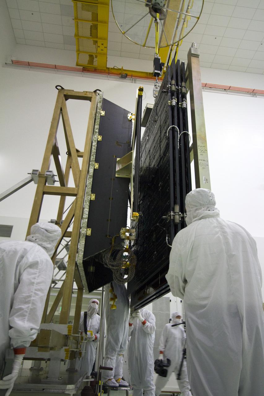 TITUSVILLE, Fla. -- Technicians in the Astrotech payload processing facility in Titusville, Fla., process a solar panel that will help power NASA's Juno spacecraft on a mission to Jupiter. Power-generating panels on three sets of solar arrays will extend outward from Juno’s hexagonal body, giving the overall spacecraft a span of more than 66 feet in order to operate at such a great distance from the sun. Juno is scheduled to launch aboard an Atlas V rocket from Cape Canaveral, Fla., on Aug. 5, 2011, reaching Jupiter in July 2016. The spacecraft will orbit the giant planet more than 30 times, skimming to within 3,000 miles above its cloud tops, for about one year. With its suite of science instruments, the spacecraft will investigate the existence of a solid planetary core, map Jupiter's intense magnetic field, measure the amount of water and ammonia in the deep atmosphere, and observe the planet's auroras. For more information visit, www.nasa.gov/juno. Photo credit: NASA/Jack Pfaller