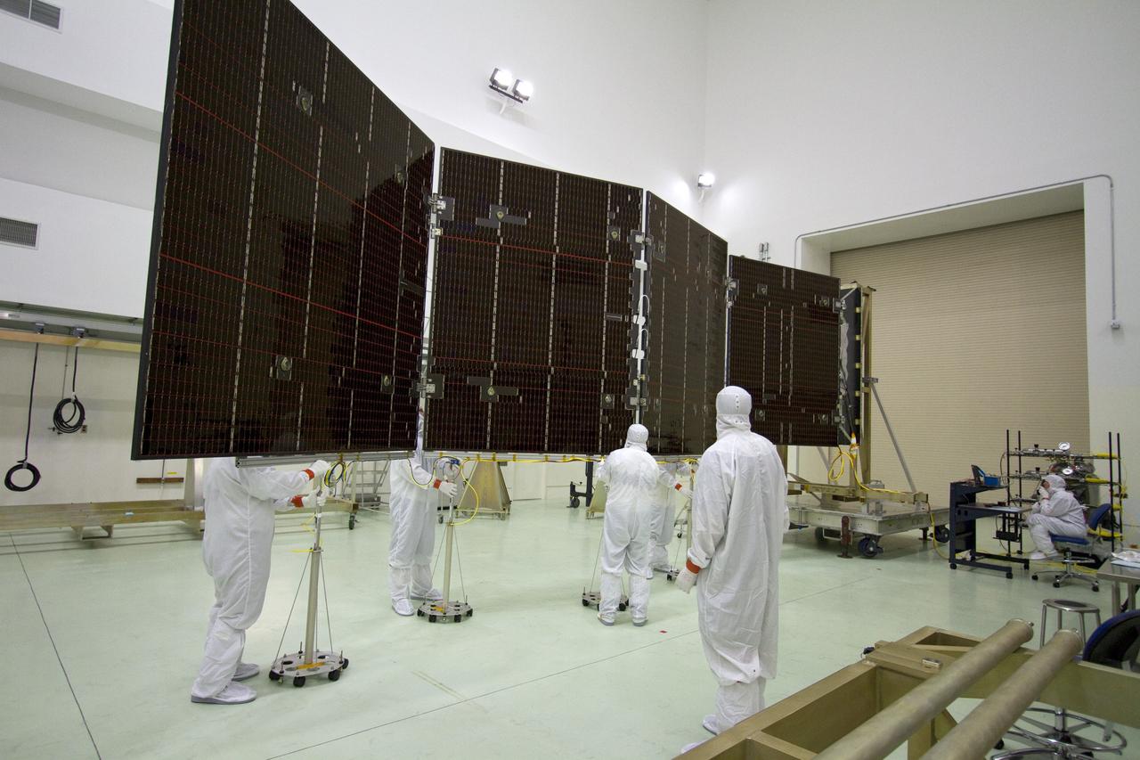 CAPE CANAVERAL, Fla. -- Technicians in the Astrotech payload processing facility in Titusville, Fla., unfurl a solar panel that will help power NASA's Juno spacecraft on a mission to Jupiter. Power-generating panels on three sets of solar arrays will extend outward from Juno’s hexagonal body, giving the overall spacecraft a span of more than 66 feet in order to operate at such a great distance from the sun. Juno is scheduled to launch aboard an Atlas V rocket from Cape Canaveral, Fla., on Aug. 5, 2011, reaching Jupiter in July 2016. The spacecraft will orbit the giant planet more than 30 times, skimming to within 3,000 miles above its cloud tops, for about one year. With its suite of science instruments, the spacecraft will investigate the existence of a solid planetary core, map Jupiter's intense magnetic field, measure the amount of water and ammonia in the deep atmosphere, and observe the planet's auroras. For more information visit, www.nasa.gov/juno. Photo credit: NASA/Jack Pfaller