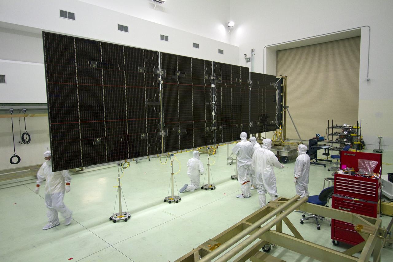 CAPE CANAVERAL, Fla. -- Technicians in the Astrotech payload processing facility in Titusville, Fla., check out an unfurled solar panel that will help power NASA's Juno spacecraft on a mission to Jupiter. Power-generating panels on three sets of solar arrays will extend outward from Juno’s hexagonal body, giving the overall spacecraft a span of more than 66 feet in order to operate at such a great distance from the sun. Juno is scheduled to launch aboard an Atlas V rocket from Cape Canaveral, Fla., on Aug. 5, 2011, reaching Jupiter in July 2016. The spacecraft will orbit the giant planet more than 30 times, skimming to within 3,000 miles above its cloud tops, for about one year. With its suite of science instruments, the spacecraft will investigate the existence of a solid planetary core, map Jupiter's intense magnetic field, measure the amount of water and ammonia in the deep atmosphere, and observe the planet's auroras. For more information visit, www.nasa.gov/juno. Photo credit: NASA/Jack Pfaller