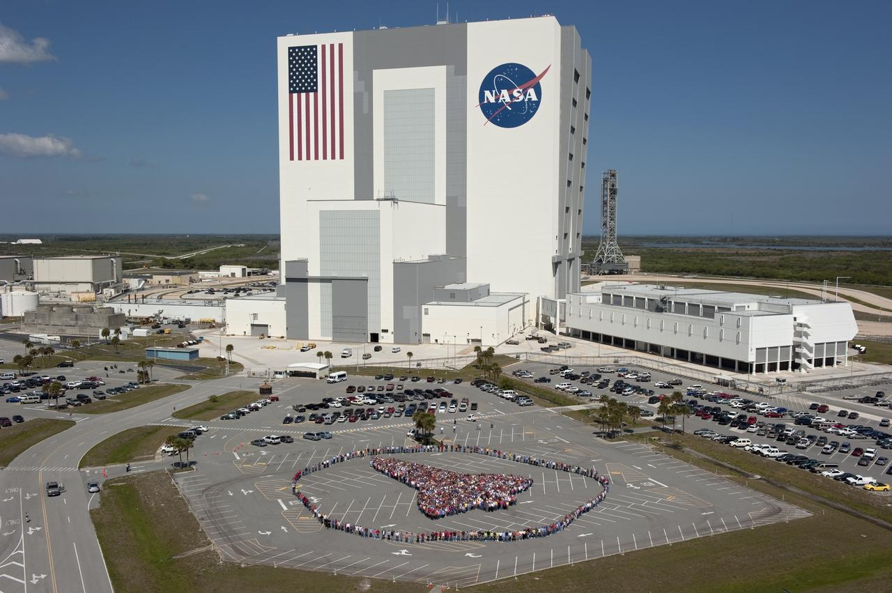 CAPE CANAVERAL, Fla. -- Thousands of NASA Kennedy Space Center employees stand side-by-side to form a full-scale outline of a space shuttle orbiter outside the Vehicle Assembly Building. The unique photo opportunity was designed to honor the Space Shuttle Program's 30-year legacy and the people who contribute to safely processing, launching and landing the vehicle.        To learn more about the space shuttle era, including videos, photos and feature stories, go to www.nasa.gov/mission_pages/shuttle/flyout/index.html. Photo credit: NASA/Kim Shiflett