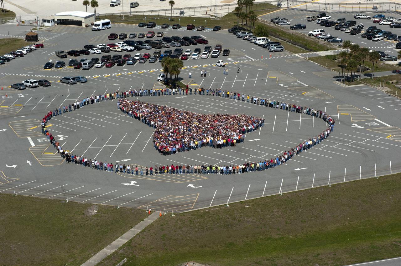 CAPE CANAVERAL, Fla. -- Thousands of NASA Kennedy Space Center employees stand side-by-side to form a full-scale outline of a space shuttle orbiter outside the Vehicle Assembly Building. The unique photo opportunity was designed to honor the Space Shuttle Program's 30-year legacy and the people who contribute to safely processing, launching and landing the vehicle.        To learn more about the space shuttle era, including videos, photos and feature stories, go to www.nasa.gov/mission_pages/shuttle/flyout/index.html. Photo credit: NASA/Kim Shiflett