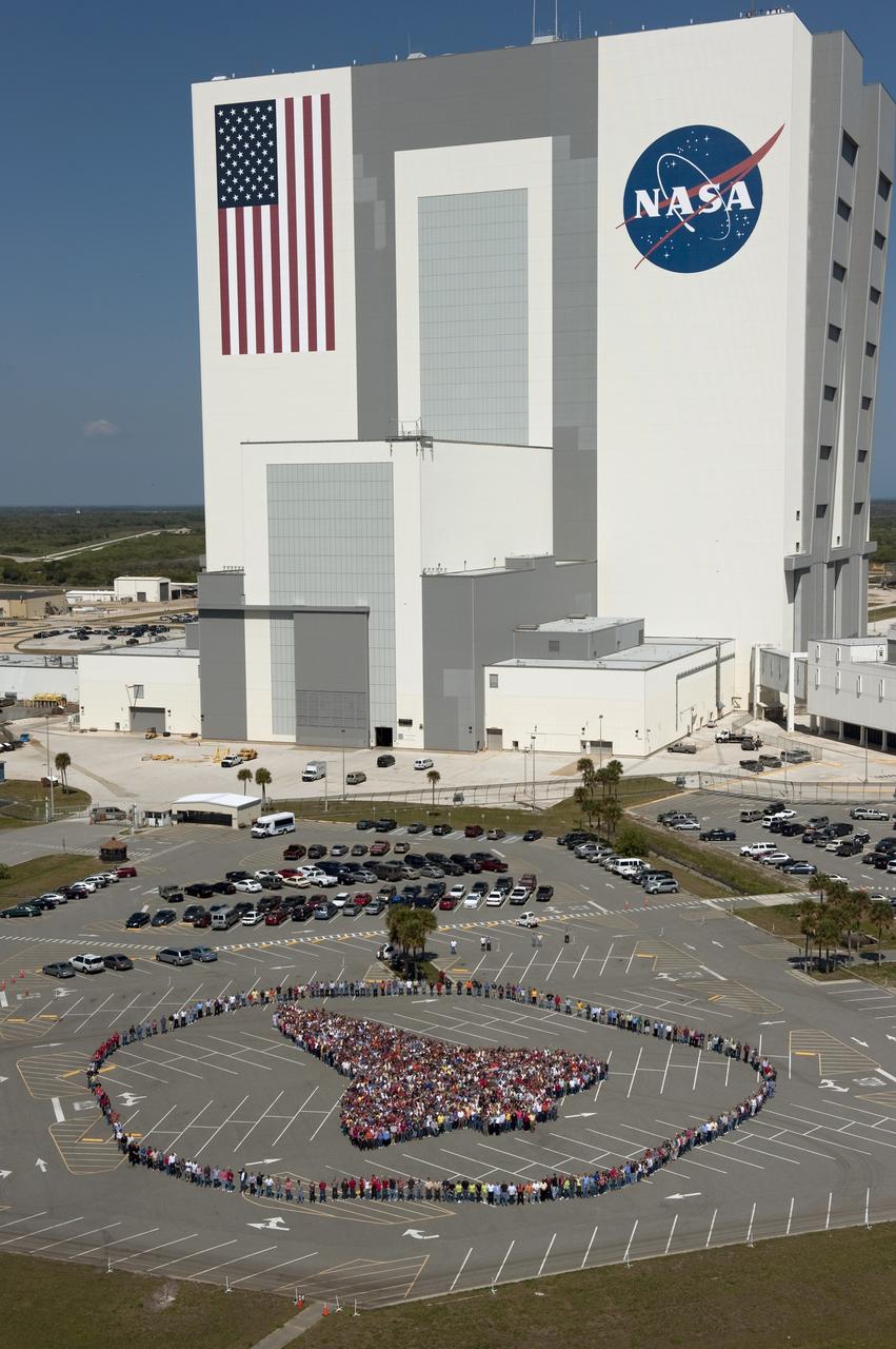 CAPE CANAVERAL, Fla. -- Thousands of NASA Kennedy Space Center employees stand side-by-side to form a full-scale outline of a space shuttle orbiter outside the Vehicle Assembly Building. The unique photo opportunity was designed to honor the Space Shuttle Program's 30-year legacy and the people who contribute to safely processing, launching and landing the vehicle.        To learn more about the space shuttle era, including videos, photos and feature stories, go to www.nasa.gov/mission_pages/shuttle/flyout/index.html. Photo credit: NASA/Kim Shiflett