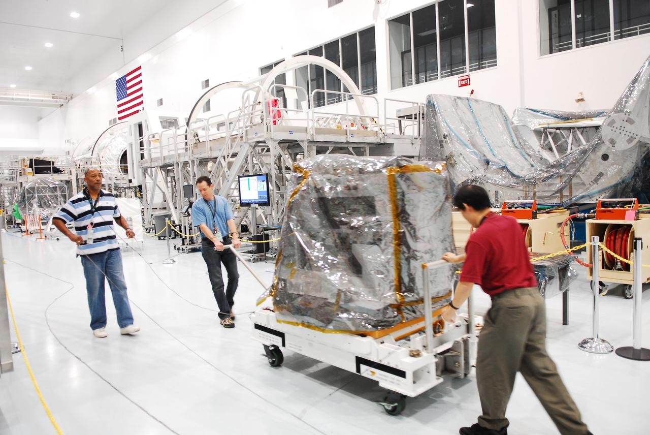 CAPE CANAVERAL, Fla. -- Technicians transport a system that will investigate the potential for robotically refueling existing spacecraft in orbit to a low bay test cell in the Space Station Processing Facility at NASA's Kennedy Space Center in Florida. Called the Robotic Refueling Mission RRM, the system will be processed to fly aboard space shuttle Atlantis on the STS-135 mission to the International Space Station. Atlantis and its STS-135 crew are scheduled to carry the Raffaello multipurpose logistics module packed with supplies, logistics and spare parts to the space station. The mission also will return a failed ammonia pump module to help NASA better understand the failure mechanism and improve pump designs for future systems. STS-135, targeted to launch June 28, will be the 33rd flight of Atlantis, the 37th shuttle mission to the space station, and the 135th and final mission of NASA's Space Shuttle Program. For more information visit, www.nasa.gov/mission_pages/shuttle/shuttlemissions/sts135/index.html. Photo credit: NASA/Jim Grossmann