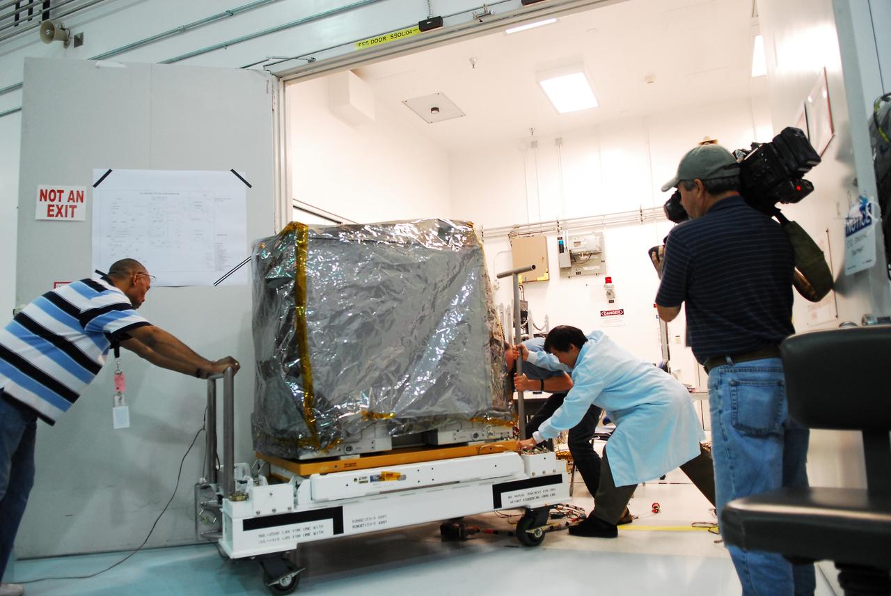 CAPE CANAVERAL, Fla. -- Technicians transport a system that will investigate the potential for robotically refueling existing spacecraft in orbit to a low bay test cell in the Space Station Processing Facility at NASA's Kennedy Space Center in Florida. Called the Robotic Refueling Mission RRM, the system will be processed to fly aboard space shuttle Atlantis on the STS-135 mission to the International Space Station. Atlantis and its STS-135 crew are scheduled to carry the Raffaello multipurpose logistics module packed with supplies, logistics and spare parts to the space station. The mission also will return a failed ammonia pump module to help NASA better understand the failure mechanism and improve pump designs for future systems. STS-135, targeted to launch June 28, will be the 33rd flight of Atlantis, the 37th shuttle mission to the space station, and the 135th and final mission of NASA's Space Shuttle Program. For more information visit, www.nasa.gov/mission_pages/shuttle/shuttlemissions/sts135/index.html. Photo credit: NASA/Jim Grossmann