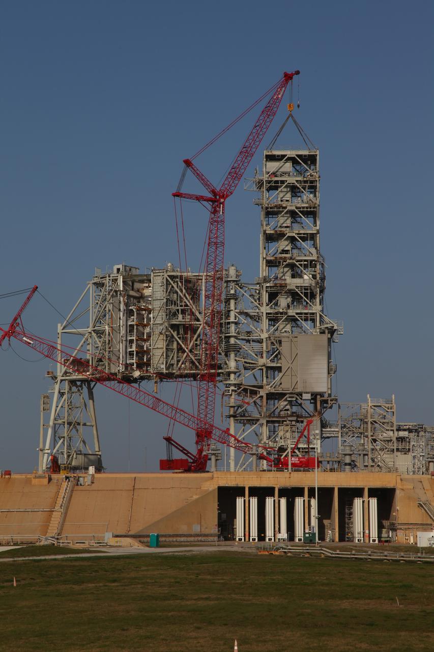 CAPE CANAVERAL, Fla. -- A large crane dismantles the fixed service structure FSS piece by piece on Launch Pad 39B at NASA's Kennedy Space Center in Florida. Work to remove the rotating service structure RSS also continues at the pad. The FSS and RSS were designed to support the unique needs of the Space Shuttle Program. In 2009, the pad was no longer needed for the shuttle program, so it is being restructured for future use.      Its new design will feature a "clean pad" for rockets to come with their own launcher, making it more versatile for a number of vehicles. The transformation also includes the refurbishment of the liquid oxygen and liquid hydrogen tanks and the upgrade of about 1.3 million feet of cable. The new lightning protection system, which was in place for the October 2009 launch of Ares I-X, will remain. For information on NASA's future plans, visit www.nasa.gov. Photo credit: NASA/Frankie Martin