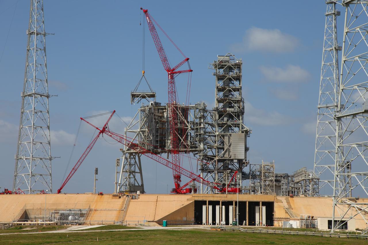 CAPE CANAVERAL, Fla. -- A large crane dismantles the fixed service structure (FSS) piece by piece on Launch Pad 39B at NASA's Kennedy Space Center in Florida. Work to remove the rotating service structure (RSS) also continues at the pad. The FSS and RSS were designed to support the unique needs of the Space Shuttle Program. In 2009, the pad was no longer needed for the shuttle program, so it is being restructured for future use.    Its new design will feature a "clean pad" for rockets to come with their own launcher, making it more versatile for a number of vehicles. The transformation also includes the refurbishment of the liquid oxygen and liquid hydrogen tanks and the upgrade of about 1.3 million feet of cable. The new lightning protection system, which was in place for the October 2009 launch of Ares I-X, will remain. For information on NASA's future plans, visit www.nasa.gov. Photo credit: NASA/Frankie Martin