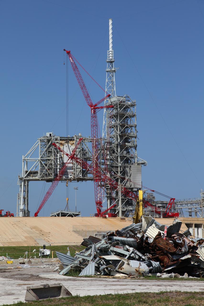 CAPE CANAVERAL, Fla. -- A large crane dismantles the fixed service structure (FSS) piece by piece on Launch Pad 39B at NASA's Kennedy Space Center in Florida. Work to remove the rotating service structure (RSS) also continues at the pad. The FSS and RSS were designed to support the unique needs of the Space Shuttle Program. In 2009, the pad was no longer needed for the shuttle program, so it is being restructured for future use.    Its new design will feature a "clean pad" for rockets to come with their own launcher, making it more versatile for a number of vehicles. The transformation also includes the refurbishment of the liquid oxygen and liquid hydrogen tanks and the upgrade of about 1.3 million feet of cable. The new lightning protection system, which was in place for the October 2009 launch of Ares I-X, will remain. For information on NASA's future plans, visit www.nasa.gov. Photo credit: NASA/Frankie Martin