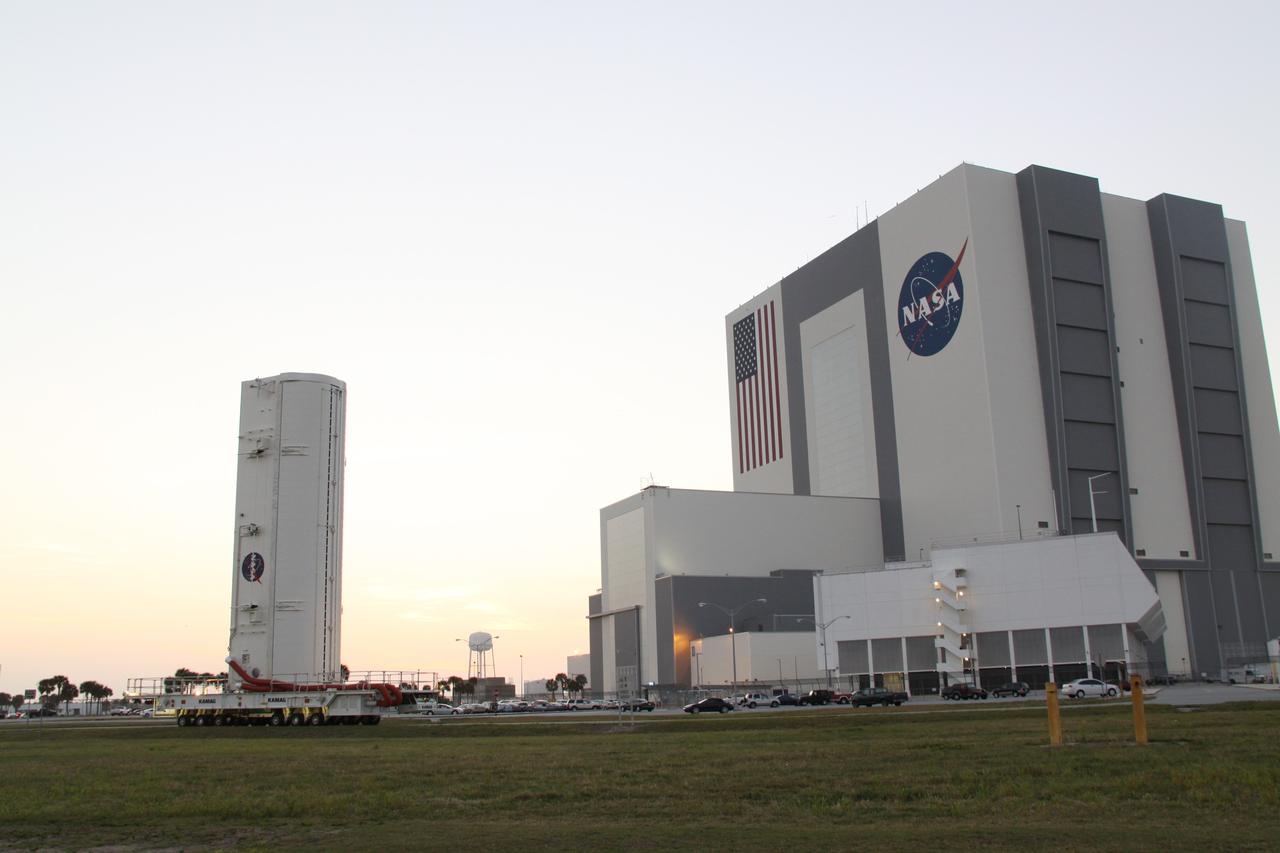 CAPE CANAVERAL, Fla. -- A canister, carrying the Alpha Magnetic Spectrometer-2 (AMS) and Express Logistics Carrier-3 for space shuttle Endeavour's STS-134 mission, moves past the Vehicle Assembly Building on its journey from the Canister Rotation Facility to Launch Pad 39A at NASA's Kennedy Space Center in Florida. At the pad, crews will move the payload into the Payload Ground Handling Mechanism (PGHM), and the rotating service structure (RSS) that protects the shuttle from the elements and provides access to its components will be rotated back into place. The payload is scheduled to be installed into the shuttle's cargo bay March 25. Endeavour and its six-member STS-134 crew are targeted to lift off April 19 at 7:48 p.m. EDT to deliver the payload to the International Space Station. This is Endeavour's final scheduled mission. For more information visit, www.nasa.gov/mission_pages/shuttle/shuttlemissions/sts134/index.html. Photo credit: NASA/Jack Pfaller
