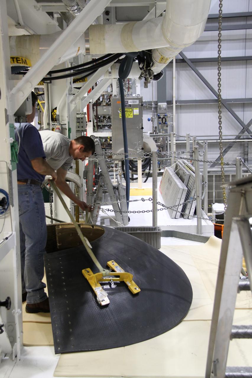 CAPE CANAVERAL, Fla. - Crews in Orbiter Processing Facility-2 at NASA's Kennedy Space Center in Florida remove space shuttle Discovery's right-hand inner heat shield from engine No. 1. The removal is part of Discovery's transition and retirement processing. Work performed on Discovery is expected to help rocket designers build next-generation spacecraft and prepare the shuttle for future public display.Photo credit: NASA/Jack Pfaller