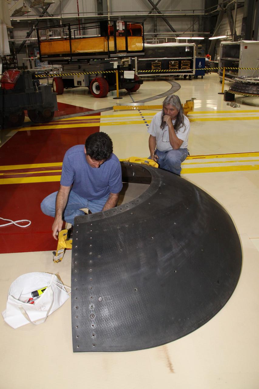 CAPE CANAVERAL, Fla. - Crews in Orbiter Processing Facility-2 at NASA's Kennedy Space Center in Florida remove space shuttle Discovery's right-hand inner heat shield from engine No. 1. The removal is part of Discovery's transition and retirement processing. Work performed on Discovery is expected to help rocket designers build next-generation spacecraft and prepare the shuttle for future public display.Photo credit: NASA/Jack Pfaller