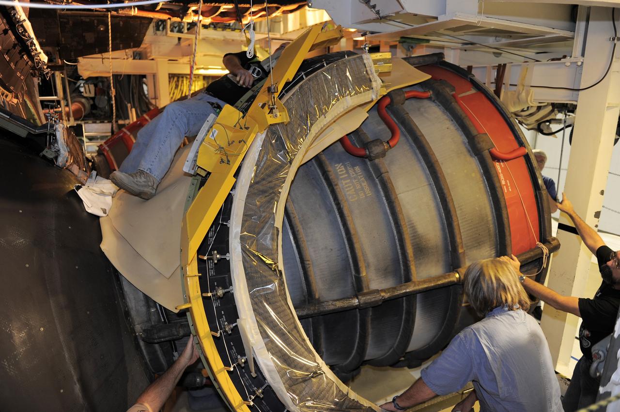 CAPE CANAVERAL, Fla. - Crews in Orbiter Processing Facility-2 at NASA's Kennedy Space Center in Florida remove space shuttle Discovery's right-hand inner heat shield from engine No. 1. The removal is part of Discovery's transition and retirement processing. Work performed on Discovery is expected to help rocket designers build next-generation spacecraft and prepare the shuttle for future public display.Photo credit: NASA/Kim Shiflett