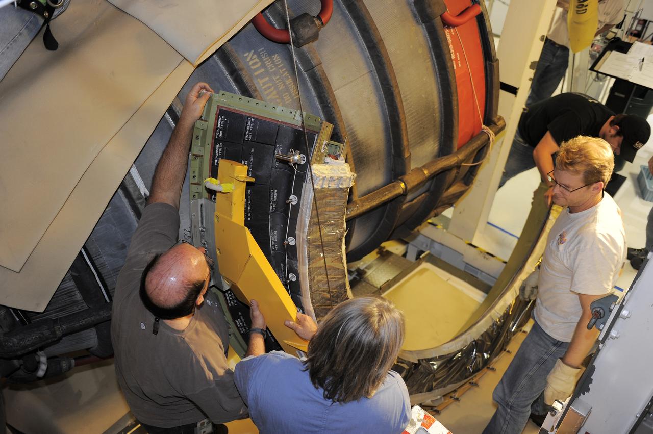 CAPE CANAVERAL, Fla. - Crews in Orbiter Processing Facility-2 at NASA's Kennedy Space Center in Florida remove space shuttle Discovery's right-hand inner heat shield from engine No. 1. The removal is part of Discovery's transition and retirement processing. Work performed on Discovery is expected to help rocket designers build next-generation spacecraft and prepare the shuttle for future public display.Photo credit: NASA/Kim Shiflett