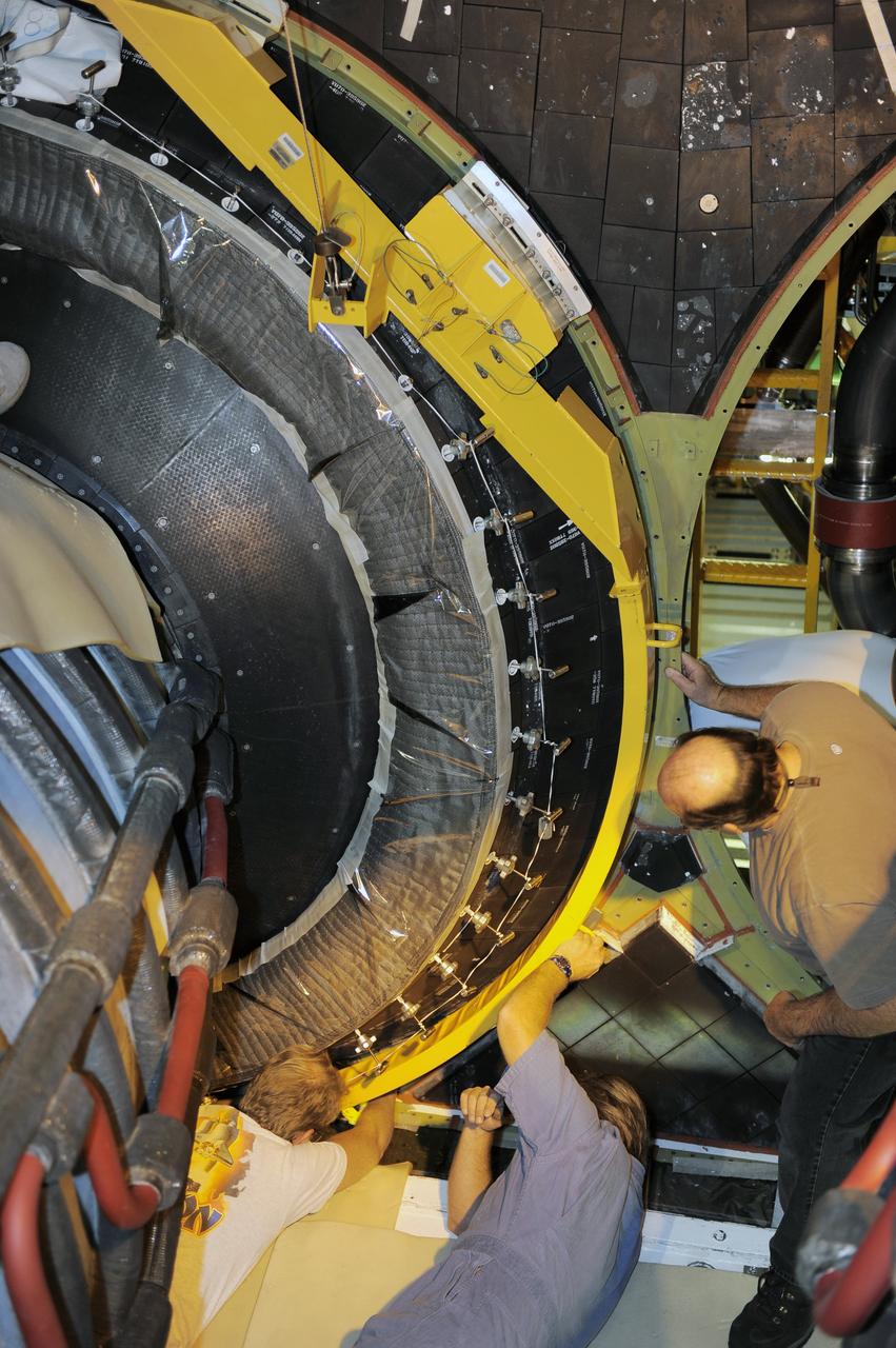 CAPE CANAVERAL, Fla. - Crews in Orbiter Processing Facility-2 at NASA's Kennedy Space Center in Florida remove space shuttle Discovery's right-hand inner heat shield from engine No. 1. The removal is part of Discovery's transition and retirement processing. Work performed on Discovery is expected to help rocket designers build next-generation spacecraft and prepare the shuttle for future public display.Photo credit: NASA/Kim Shiflett