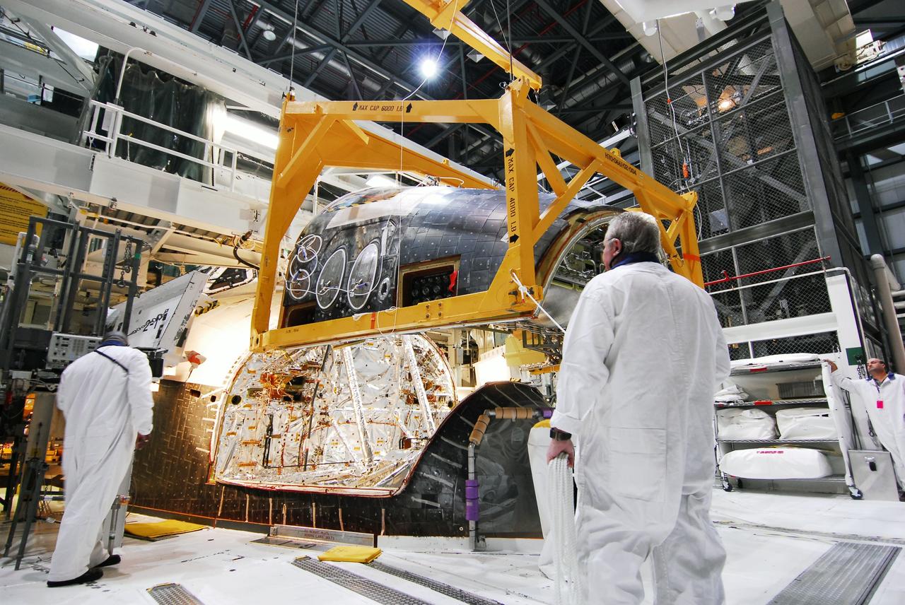 CAPE CANAVERAL, Fla. - Crews in Orbiter Processing Facility-2 at NASA's Kennedy Space Center in Florida remove space shuttle Discovery's forward reaction control system (FRCS), which helped steer the shuttle in orbit. To maneuver, the FRCS used hypergolic fuel and oxidizer, which were purged from Discovery after its final spaceflight, STS-133. Next, the FRCS will be shipped to a maintenance facility at White Sands Space Harbor in New Mexico, where additional inspections will be performed and its components made safe to go on public display. The transition and retirement processing is expected to help rocket designers build next-generation spacecraft and prepare the shuttle for display.                    Photo credit: NASA/Jim Grossmann