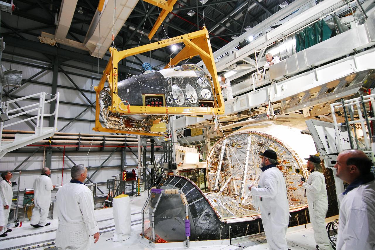 CAPE CANAVERAL, Fla. - Crews in Orbiter Processing Facility-2 at NASA's Kennedy Space Center in Florida remove space shuttle Discovery's forward reaction control system (FRCS), which helped steer the shuttle in orbit. To maneuver, the FRCS used hypergolic fuel and oxidizer, which were purged from Discovery after its final spaceflight, STS-133. Next, the FRCS will be shipped to a maintenance facility at White Sands Space Harbor in New Mexico, where additional inspections will be performed and its components made safe to go on public display. The transition and retirement processing is expected to help rocket designers build next-generation spacecraft and prepare the shuttle for display.                Photo credit: NASA/Jim Grossmann