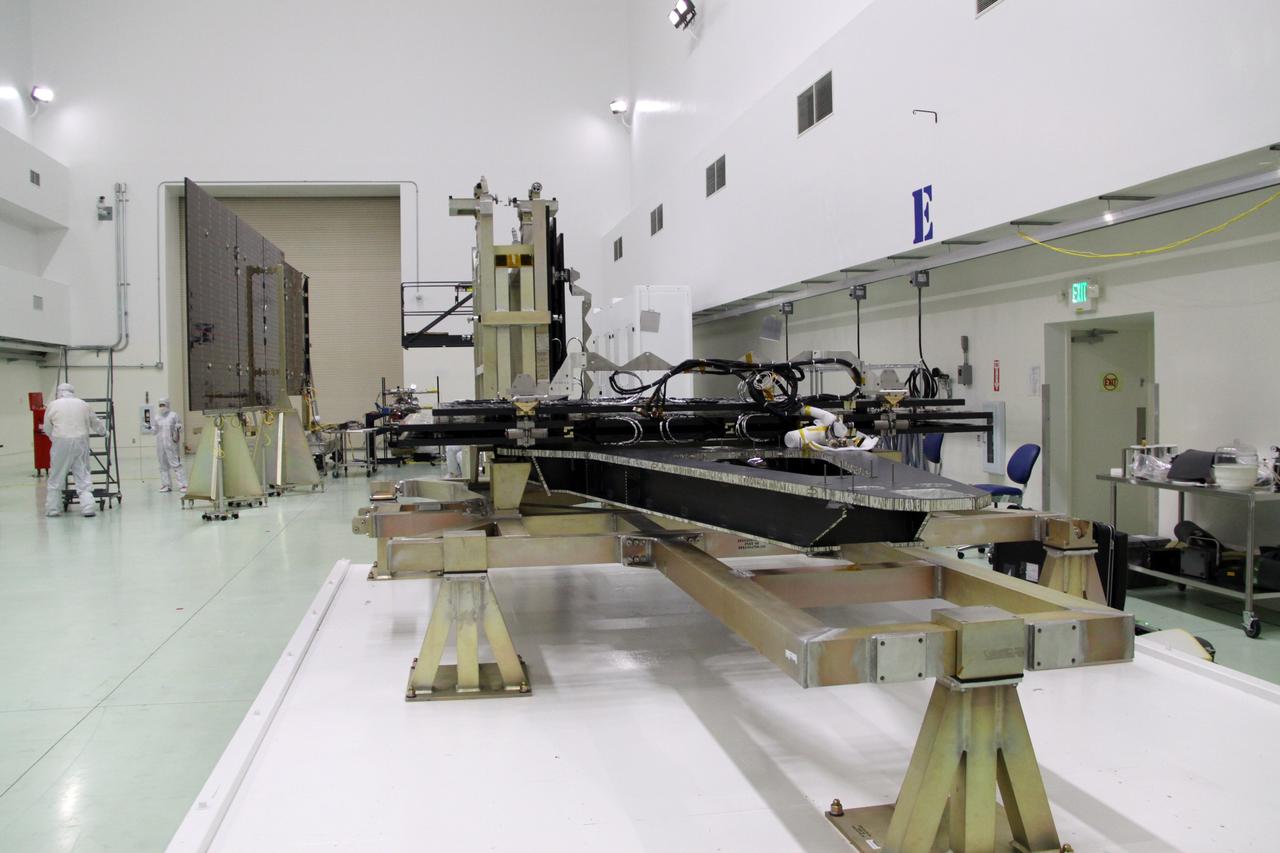 CAPE CANAVERAL, Fla. -- Technicians in the Astrotech payload processing facility in Titusville, Fla., test the electrical continuity of a solar array, left, that will help power NASA's Juno spacecraft on a mission to Jupiter. Two other arrays are in work stands on the right. Power-generating panels on three sets of solar arrays will extend outward from Juno’s hexagonal body, giving the overall spacecraft a span of more than 66 feet in order to operate at such a great distance from the sun. Juno is scheduled to launch aboard an Atlas V rocket from Cape Canaveral, Fla., on Aug. 5, 2011, reaching Jupiter in July 2016. The spacecraft will orbit the giant planet more than 30 times, skimming to within 3,000 miles above its cloud tops, for about one year. With its suite of science instruments, the spacecraft will investigate the existence of a solid planetary core, map Jupiter's intense magnetic field, measure the amount of water and ammonia in the deep atmosphere, and observe the planet's auroras. For more information visit, www.nasa.gov/juno. Photo credit: NASA/Jack Pfaller