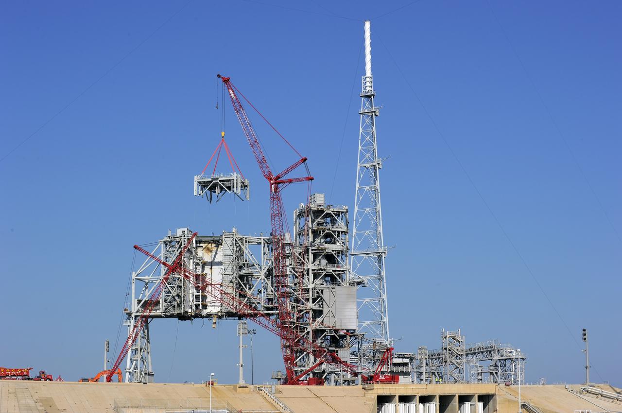 CAPE CANAVERAL, Fla. -- A large crane dismantles another level of the fixed service structure (FSS) on Launch Pad 39B at NASA's Kennedy Space Center in Florida. Work to remove the rotating service structure (RSS) also continues at the pad. The FSS and RSS were designed to support the unique needs of the Space Shuttle Program. In 2009, the pad was no longer needed for the shuttle program, so it is being restructured for future use.            Its new design will feature a "clean pad" for rockets to come with their own launcher, making it more versatile for a number of vehicles. The transformation also includes the refurbishment of the liquid oxygen and liquid hydrogen tanks and the upgrade of about 1.3 million feet of cable. The new lightning protection system, which was in place for the October 2009 launch of Ares I-X, will remain. For information on NASA's future plans, visit www.nasa.gov. Photo credit: NASA/Kim Shiflett