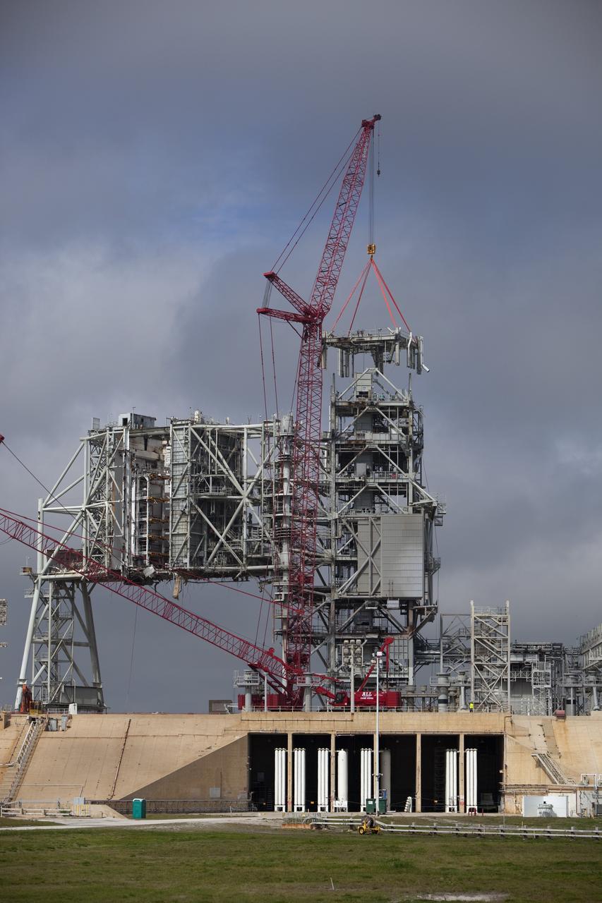 Cape Canaveral, Fla. -- A large crane dismantles the next section of the fixed service structure (FSS) on Launch Pad 39B at NASA's Kennedy Space Center in Florida. Work to remove the rotating service structure (RSS) also continues at the pad. The FSS and RSS were designed to support the unique needs of the Space Shuttle Program. In 2009, the pad was no longer needed for the shuttle program, so it is being restructured for future use. Its new design will feature a "clean pad" for rockets to come with their own launcher, making it more versatile for a number of vehicles. The new lightning protection system, which was in place for the October 2009 launch of Ares I-X, will remain. For information on NASA's future plans, visit www.nasa.gov. Photo credit: NASA/Dimitri Gerondidakis