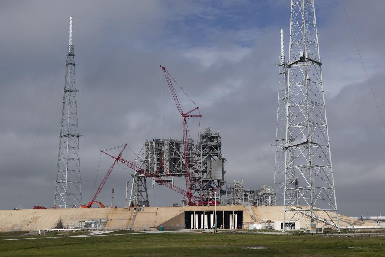 Cape Canaveral, Fla. -- A large crane dismantles the next section of the fixed service structure (FSS) on Launch Pad 39B at NASA's Kennedy Space Center in Florida. Work to remove the rotating service structure (RSS) also continues at the pad. The FSS and RSS were designed to support the unique needs of the Space Shuttle Program. In 2009, the pad was no longer needed for the shuttle program, so it is being restructured for future use. Its new design will feature a "clean pad" for rockets to come with their own launcher, making it more versatile for a number of vehicles. The new lightning protection system, which was in place for the October 2009 launch of Ares I-X, will remain. For information on NASA's future plans, visit www.nasa.gov. Photo credit: NASA/Dimitri Gerondidakis
