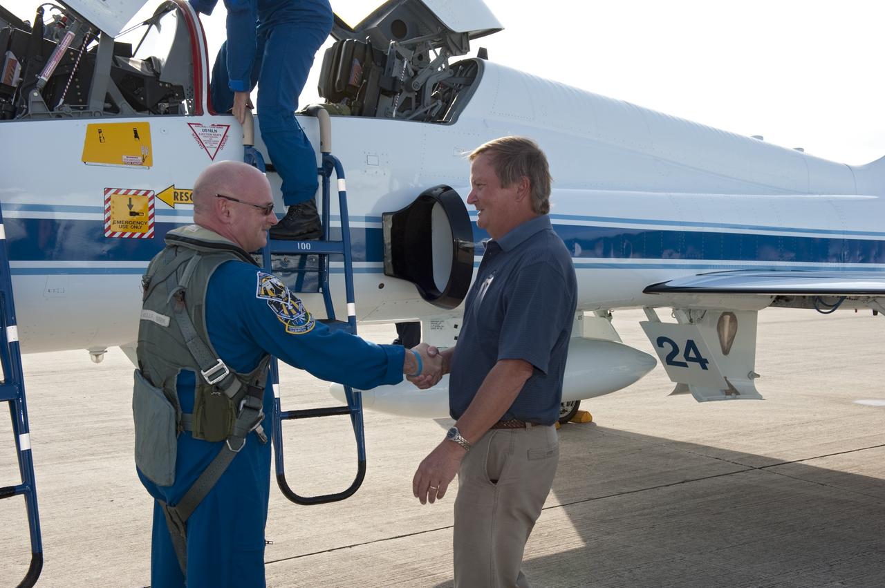 CAPE CANAVERAL, Fla. -- Shuttle Launch Director Mike Leinbach, right, greets STS-134 Commander Mark Kelly, who arrived on the Shuttle Landing Facility at NASA's Kennedy Space Center in Florida aboard a T-38 jet. While at Kennedy, space shuttle Endeavour's crew will participate in a launch countdown dress rehearsal called the Terminal Countdown Demonstration Test (TCDT) and related training in preparation for the upcoming STS-134 mission.      Endeavour and its six STS-134 crew members will deliver the Express Logistics Carrier-3, Alpha Magnetic Spectrometer-2 (AMS), a high-pressure gas tank, additional spare parts for the Dextre robotic helper and micrometeoroid debris shields to the International Space Station. This will be the final spaceflight for Endeavour. Launch is targeted for April 19 at 7:48 p.m. EDT. For more information visit, www.nasa.gov/mission_pages/shuttle/shuttlemissions/sts134/index.html. Photo credit: NASA/Kim Shiflett