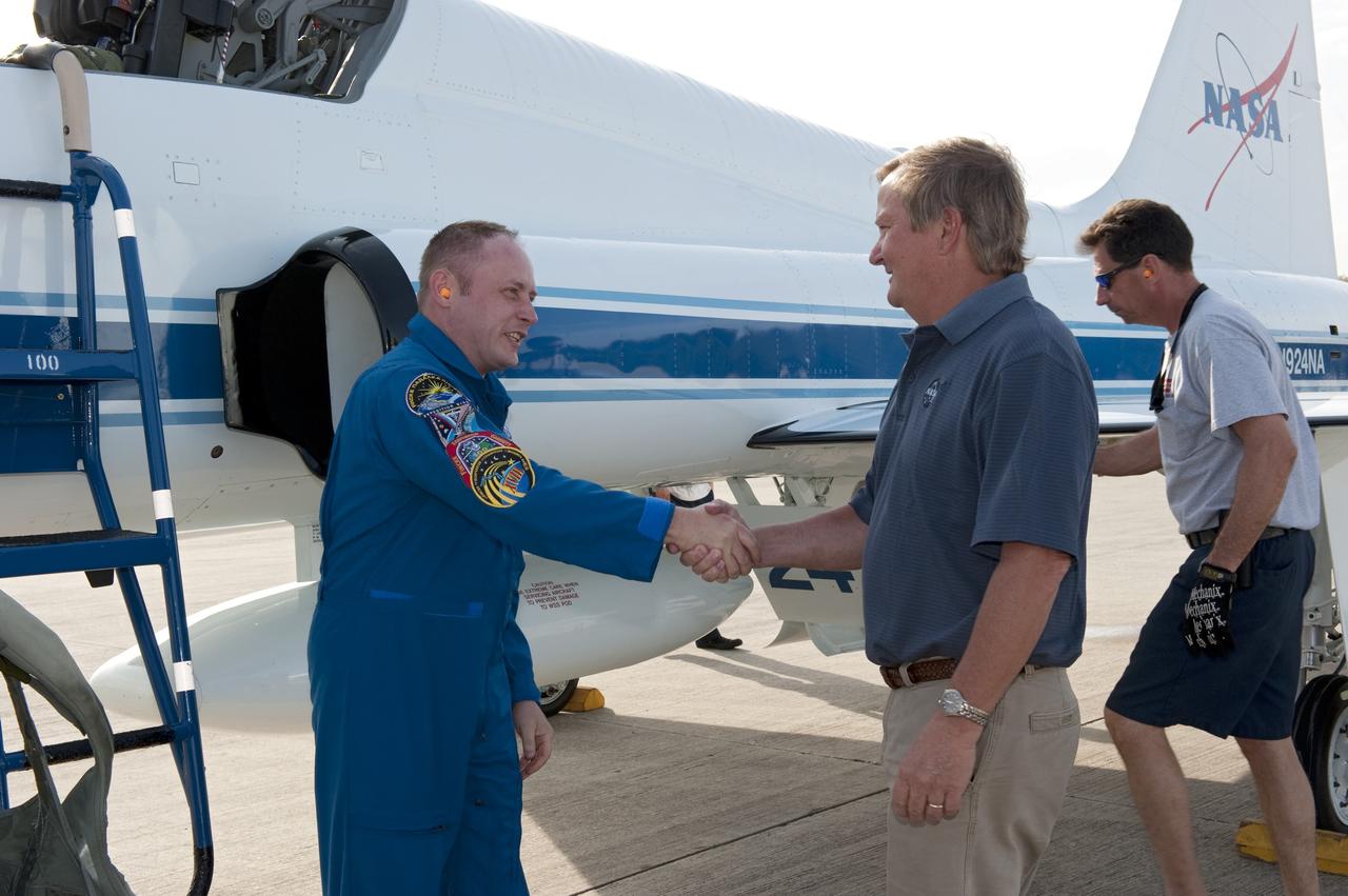 CAPE CANAVERAL, Fla. -- Shuttle Launch Director Mike Leinbach greets STS-134 Mission Specialist Michael Fincke, who arrived on the Shuttle Landing Facility at NASA's Kennedy Space Center in Florida aboard a T-38 jet. While at Kennedy, space shuttle Endeavour's crew will participate in a launch countdown dress rehearsal called the Terminal Countdown Demonstration Test (TCDT) and related training in preparation for the upcoming STS-134 mission.    Endeavour and its six STS-134 crew members will deliver the Express Logistics Carrier-3, Alpha Magnetic Spectrometer-2 (AMS), a high-pressure gas tank, additional spare parts for the Dextre robotic helper and micrometeoroid debris shields to the International Space Station. This will be the final spaceflight for Endeavour. Launch is targeted for April 19 at 7:48 p.m. EDT. For more information visit, www.nasa.gov/mission_pages/shuttle/shuttlemissions/sts134/index.html. Photo credit: NASA/Kim Shiflett
