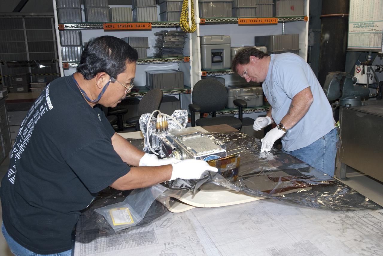 CAPE CANAVERAL, Fla. - In Orbiter Processing Facility-1 at NASA's Kennedy Space Center in Florida, technicians prepare an elbow camera for installation onto a robotic arm inside shuttle Atlantis' payload bay.              Atlantis is being prepared for the STS-135 mission, which will deliver the Raffaello multipurpose logistics module packed with supplies, logistics and spare parts to the International Space Station. STS-135 is targeted to launch June 28, and will be the last spaceflight for the Space Shuttle Program. Photo credit: NASA/Jim Grossmann