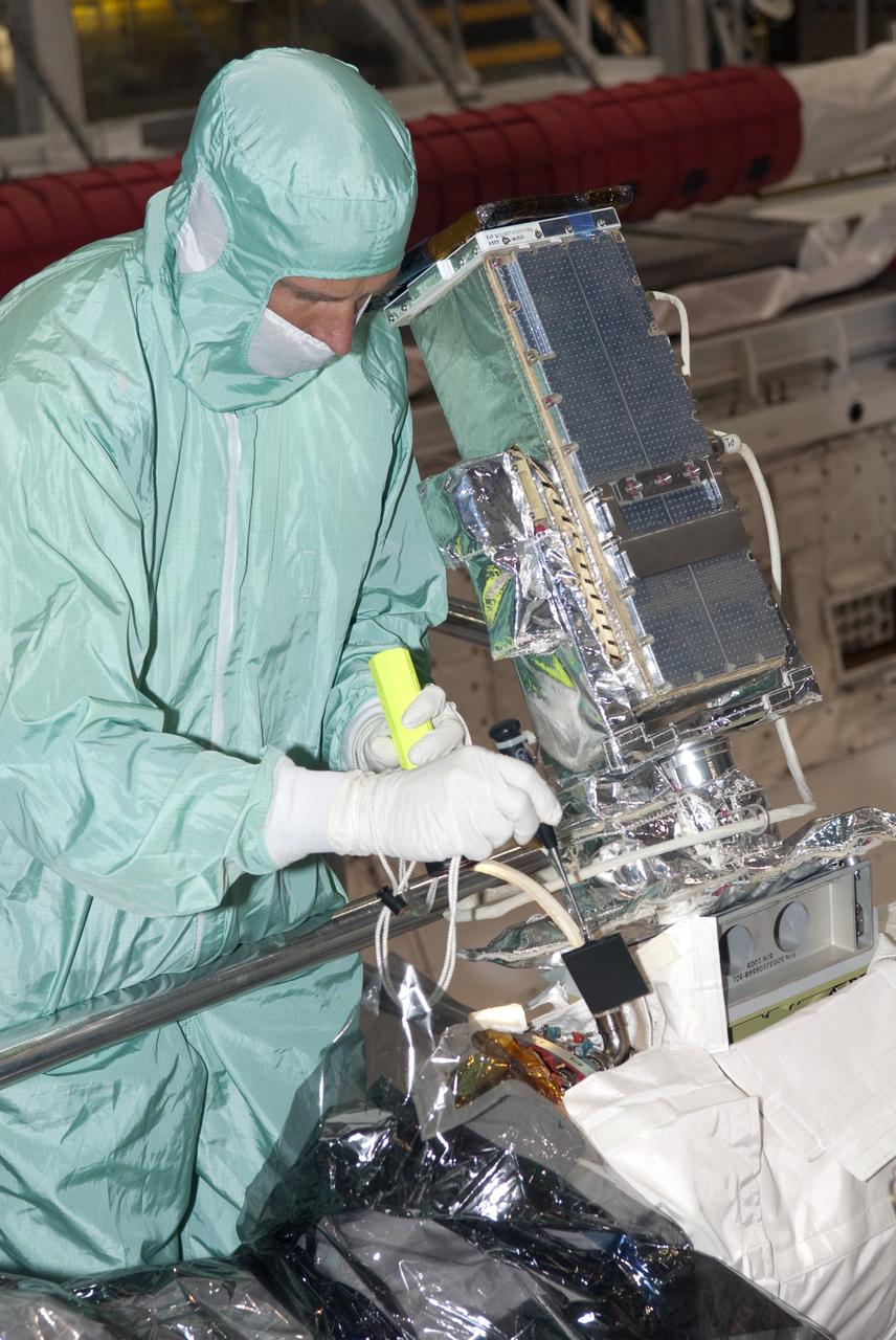 CAPE CANAVERAL, Fla. - In Orbiter Processing Facility-1 at NASA's Kennedy Space Center in Florida, a technician checks the connection of an elbow camera installed onto the robotic arm inside shuttle Atlantis' payload bay.        Atlantis is being prepared for the STS-135 mission, which will deliver the Raffaello multipurpose logistics module packed with supplies, logistics and spare parts to the International Space Station. STS-135 is targeted to launch June 28, and will be the last spaceflight for the Space Shuttle Program. Photo credit: NASA/Jim Grossmann