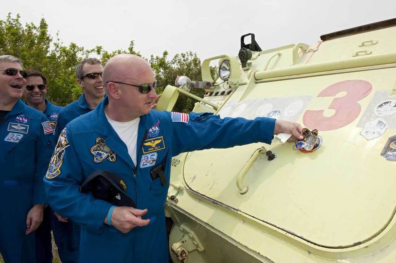 CAPE CANAVERAL, Fla. - At NASA's Kennedy Space Center in Florida, STS-134 Commander Mark Kelly jokes around with his crew mates while trying to figure out where to affix his mission's logo on an M113 armored personnel carrier. An M113 is kept at the foot of the launch pad in case an emergency exit from the pad is needed and every shuttle crew is trained on driving the vehicle before launch. Endeavour's six crew members are at Kennedy for the launch countdown dress rehearsal called the Terminal Countdown Demonstration Test (TCDT) and related training. Targeted to launch April 19 at 7:48 p.m. EDT, they will deliver the Express Logistics Carrier-3, Alpha Magnetic Spectrometer-2 (AMS), a high-pressure gas tank, additional spare parts for the Dextre robotic helper and micrometeoroid debris shields to the space station. This will be the final spaceflight for Endeavour. For more information visit, www.nasa.gov/mission_pages/shuttle/shuttlemissions/sts134/index.html. Photo credit: NASA/Kim Shiflett