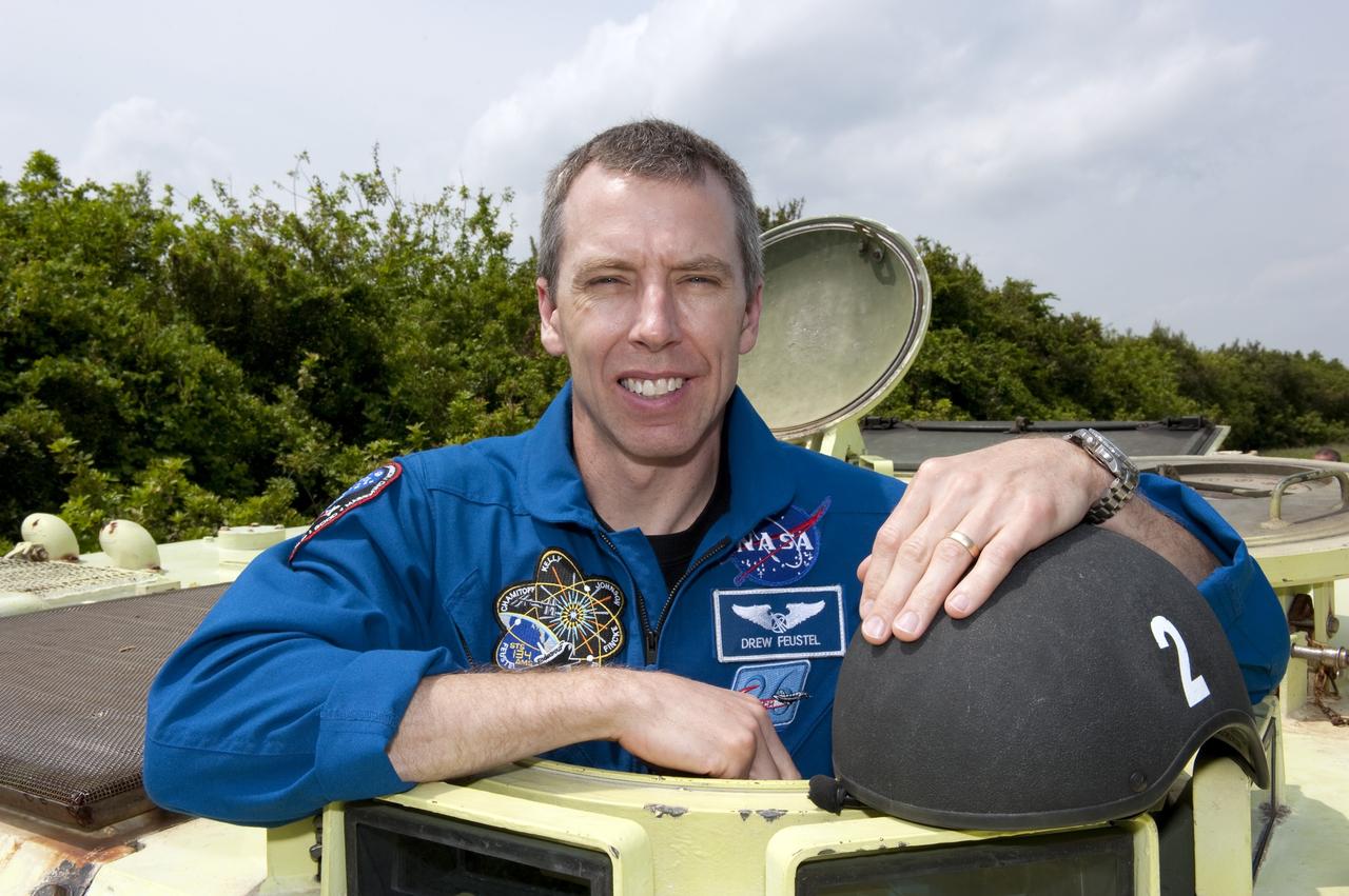 CAPE CANAVERAL, Fla. - STS-134 Mission Specialist Andrew Feustel takes time out from driving practice of the M113 armored personnel carrier to pose for a photo at NASA's Kennedy Space Center in Florida. An M113 is kept at the foot of the launch pad in case an emergency exit from the pad is needed and every shuttle crew is trained on driving the vehicle before launch. Space shuttle Endeavour's six crew members are at Kennedy for the launch countdown dress rehearsal called the Terminal Countdown Demonstration Test (TCDT) and related training. Targeted to launch April 19 at 7:48 p.m. EDT, they will deliver the Express Logistics Carrier-3, Alpha Magnetic Spectrometer-2 (AMS), a high-pressure gas tank, additional spare parts for the Dextre robotic helper and micrometeoroid debris shields to the space station. This will be the final spaceflight for Endeavour. For more information visit, www.nasa.gov/mission_pages/shuttle/shuttlemissions/sts134/index.html. Photo credit: NASA/Kim Shiflett